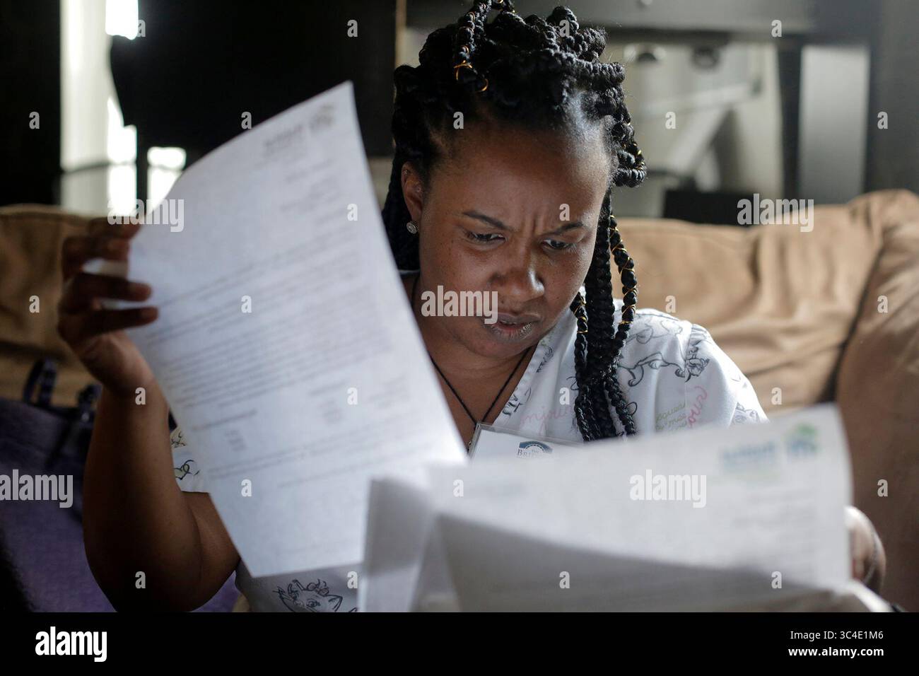 8 agosto 2018 - City, Florida, Stati Uniti - OCTAVIO JONES | Times. Tonya Neal una proprietaria di casa legge attraverso lettere che ha ricevuto da Habitat for Humanity sullo stato finanziario della sua casa nel quartiere Grant Park a est di Tampa, Florida, mercoledì 8 agosto 2018. Neal è una madre single che si prende cura delle sue figlie mentre lavora due lavori per tenere il passo con le sue bollette. (Immagine di credito: © Octavio Jones/Tampa Bay Times tramite ZUMA Wire) Foto Stock
