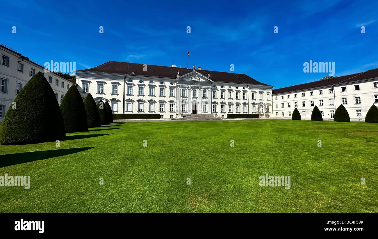 Schloss Bellevue a Berlino, la residenza ufficiale del Presidente della Germania, visto dal fronte con la sua facciata neoclassica e il prato curato. Foto Stock