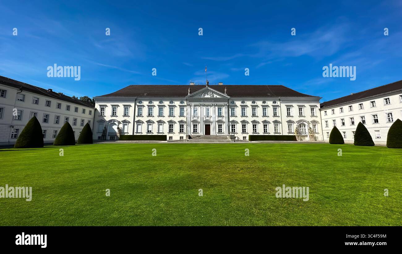 Schloss Bellevue a Berlino, la residenza ufficiale del Presidente della Germania, visto dal fronte con la sua facciata neoclassica e il prato curato. Foto Stock