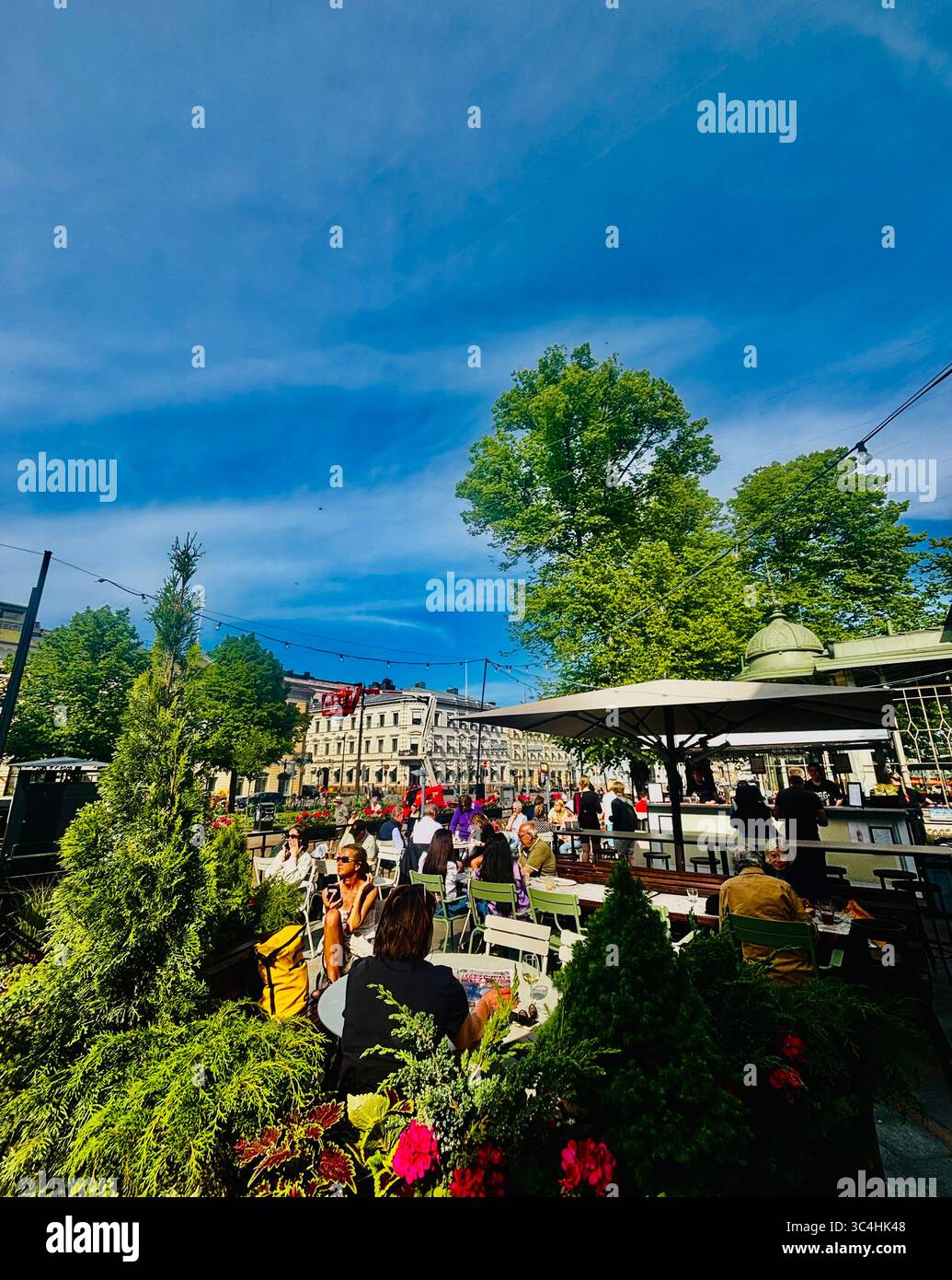Sorseggiando un drink e socializzando al ristorante Kappeli di Eteläesplanadi a Helsinki, Finlandia. Foto Stock
