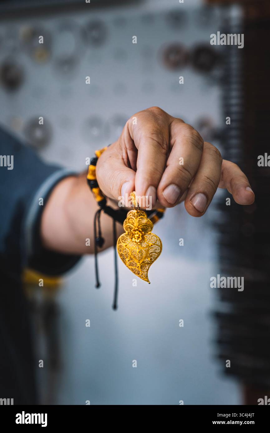 Artigianato che espone i tradizionali gioielli Minho Gold Heart in un laboratorio portoghese. Ciondolo filigrana artigianale, artigianato regionale, North P. Foto Stock