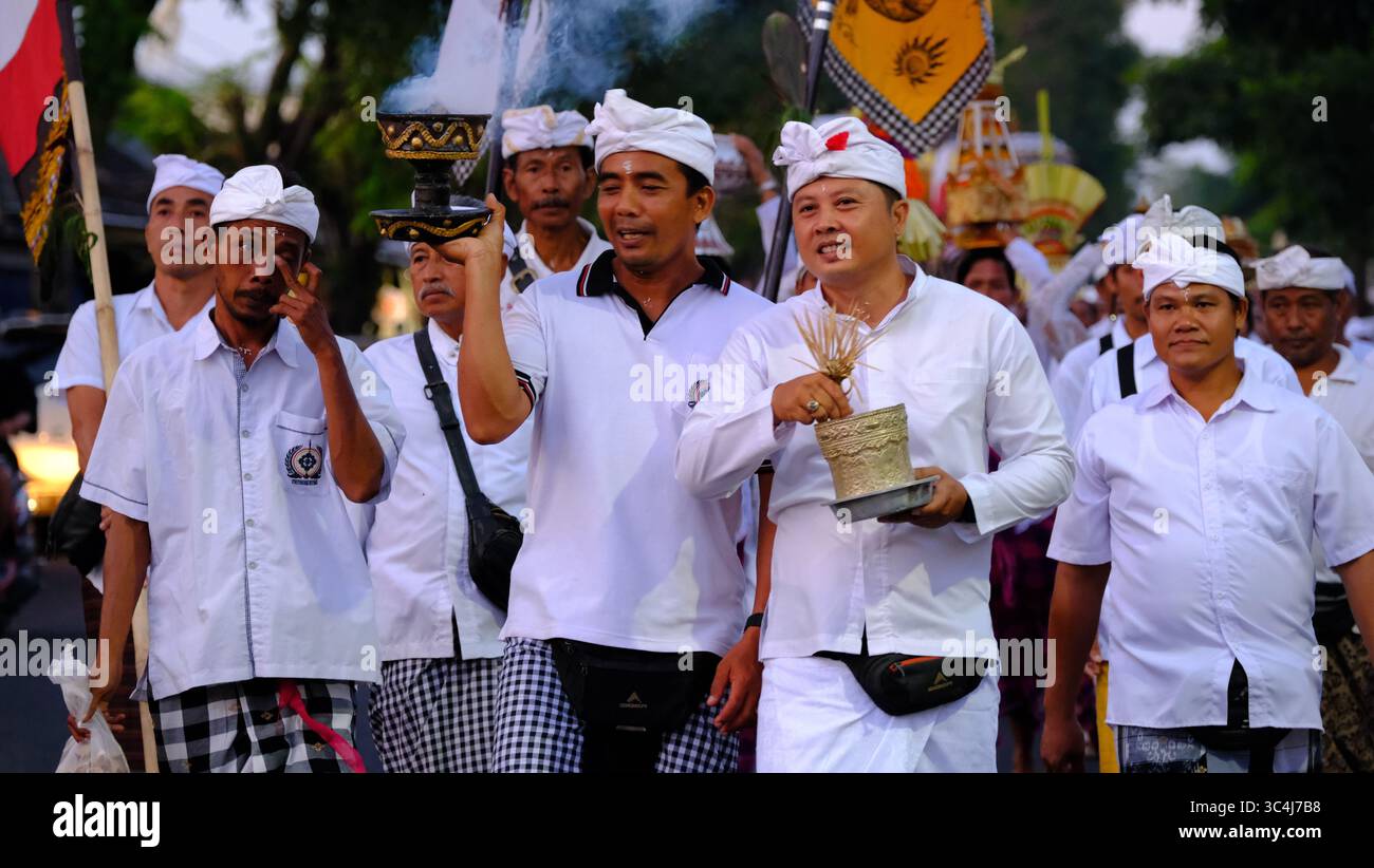 Gli uomini balinesi portano attrezzature cerimoniali Foto Stock