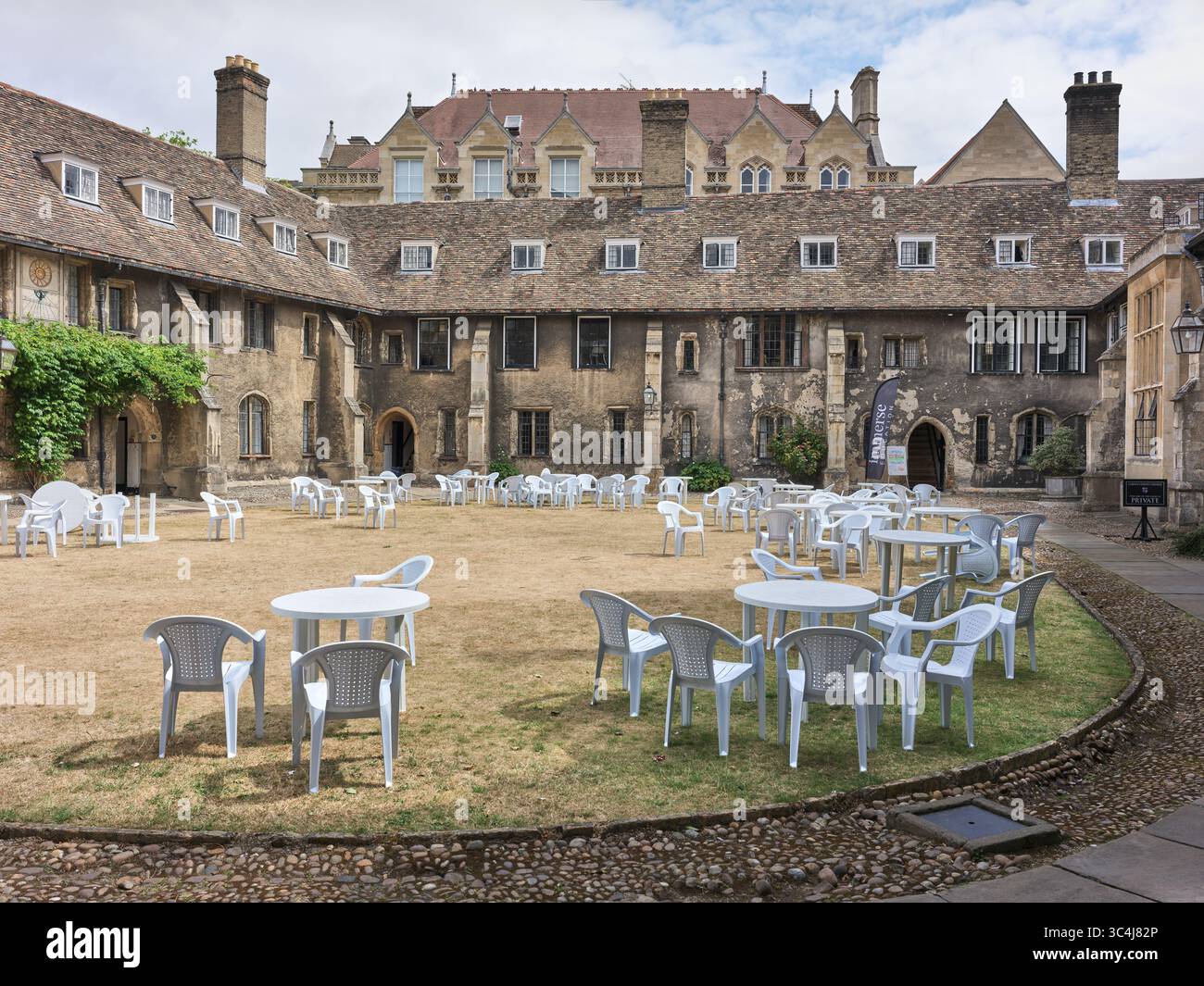 Tavoli e sedie in plastica bianca sul prato di Old Court, Corpus Christi College, Università di Cambridge, Inghilterra. Foto Stock