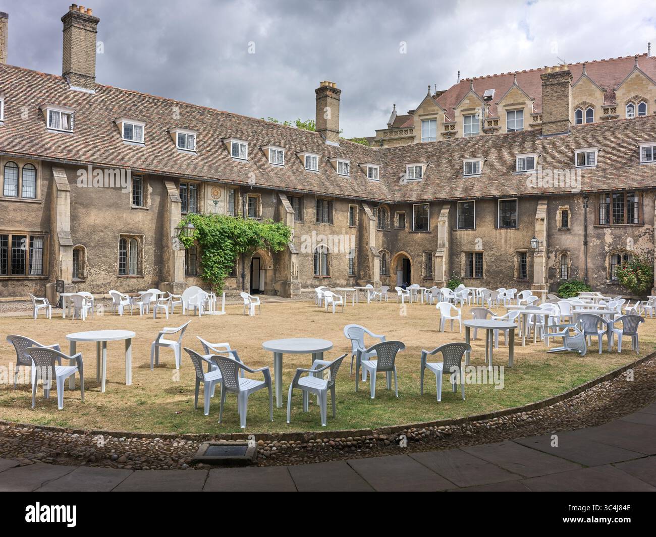 Tavoli e sedie in plastica bianca sul prato di Old Court, Corpus Christi College, Università di Cambridge, Inghilterra. Foto Stock