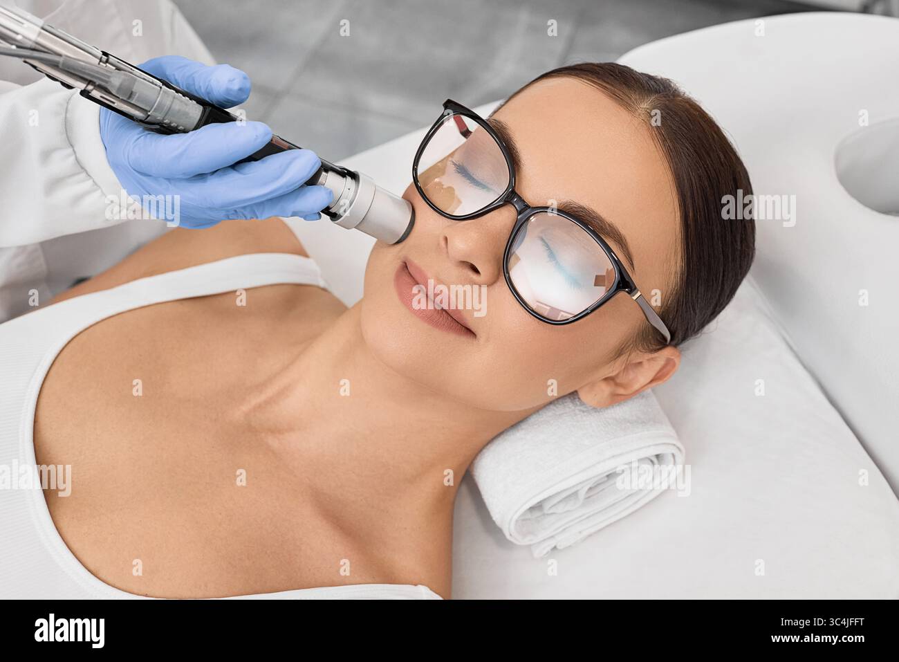 Rimozione dei peli del laser facciale. Bella donna durante la rimozione dei capelli laser e l'epilazione laser alla zona delle labbra sul viso Foto Stock