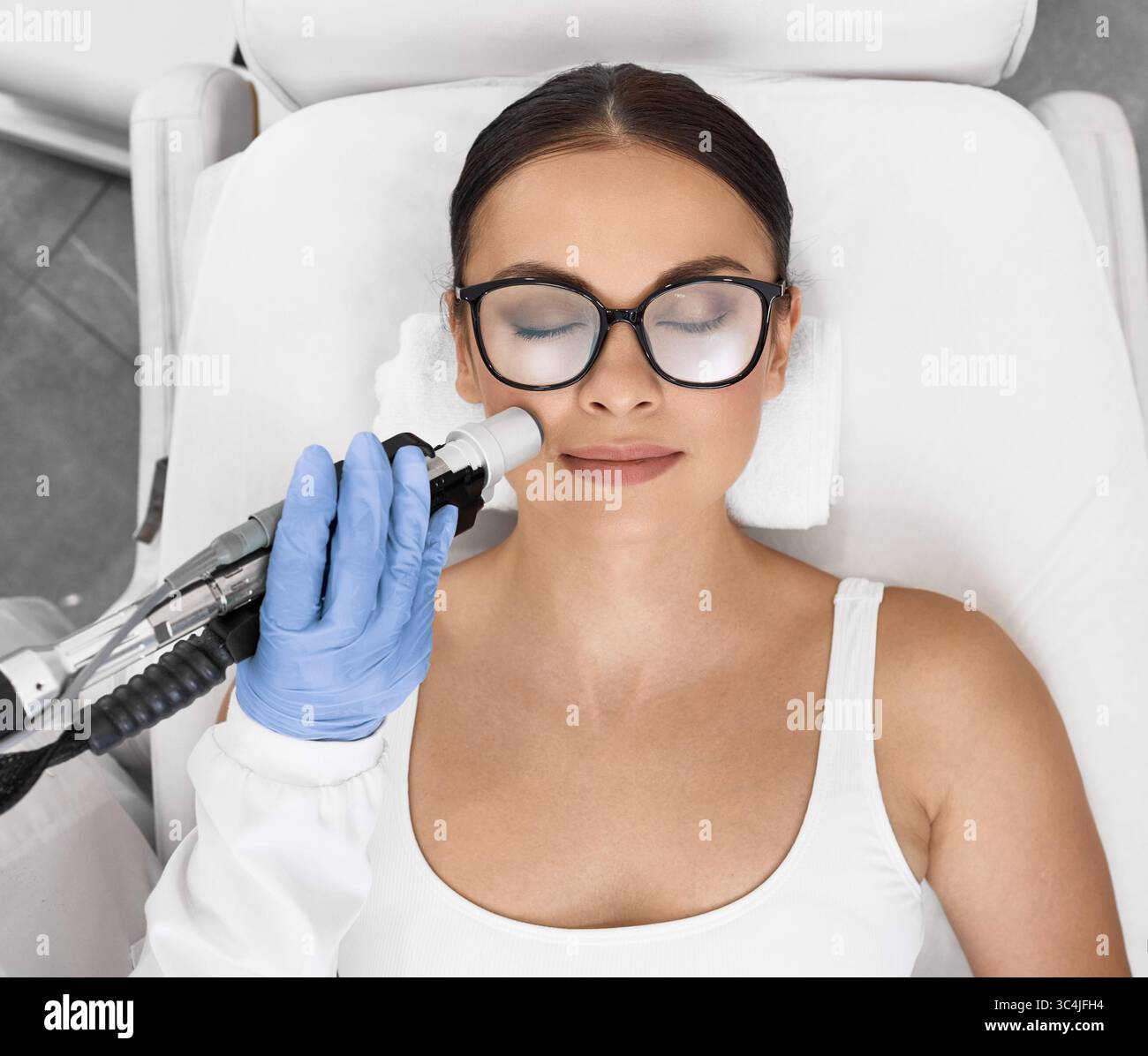 Bella donna che ha la rimozione dei capelli laser e l'epilazione laser a zona delle labbra sul suo viso al salone di cosmetologia Foto Stock