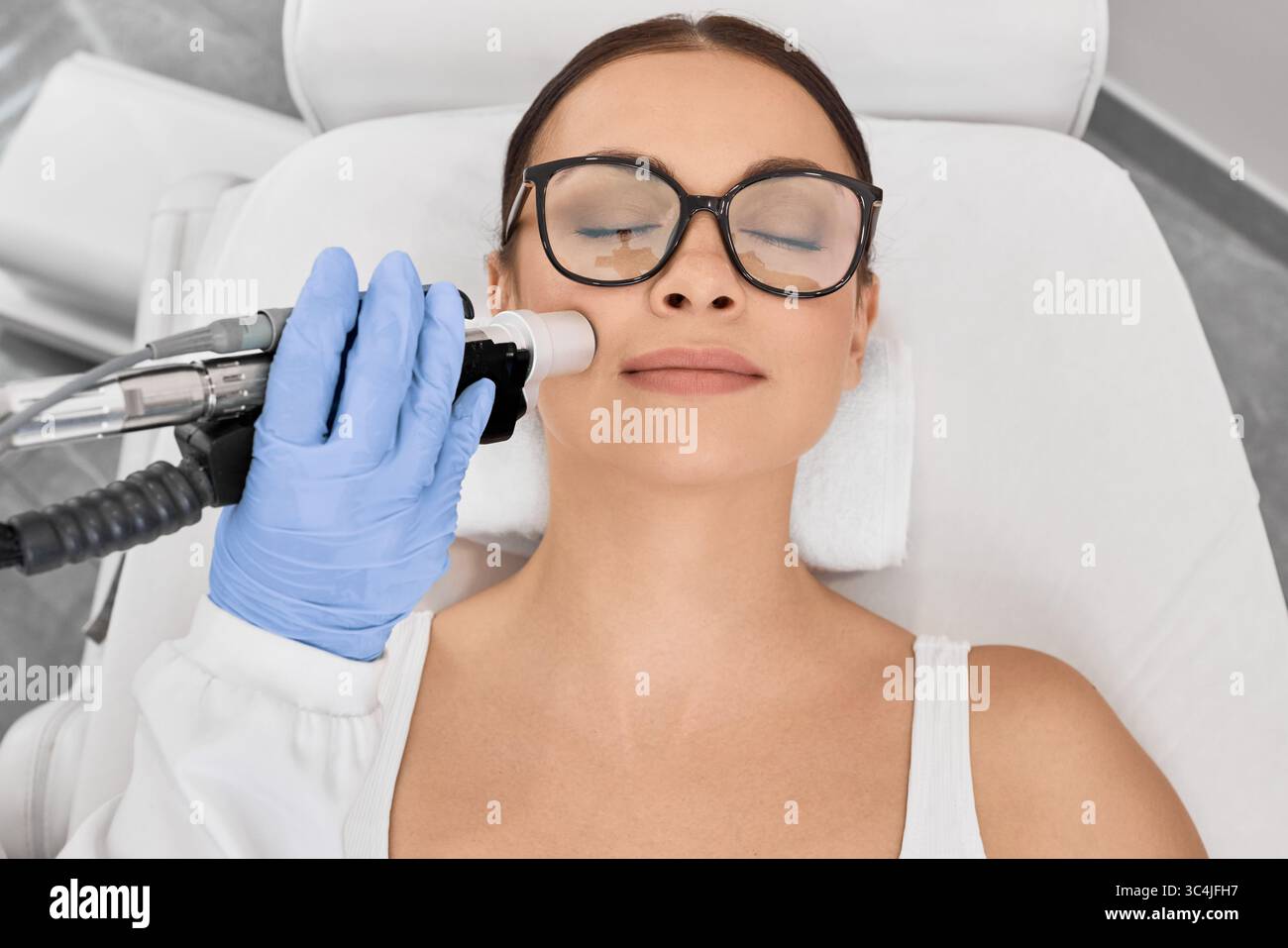 Donna che ottiene depilazione laser sul suo viso, depilazione sull'area delle labbra, vista dall'alto Foto Stock