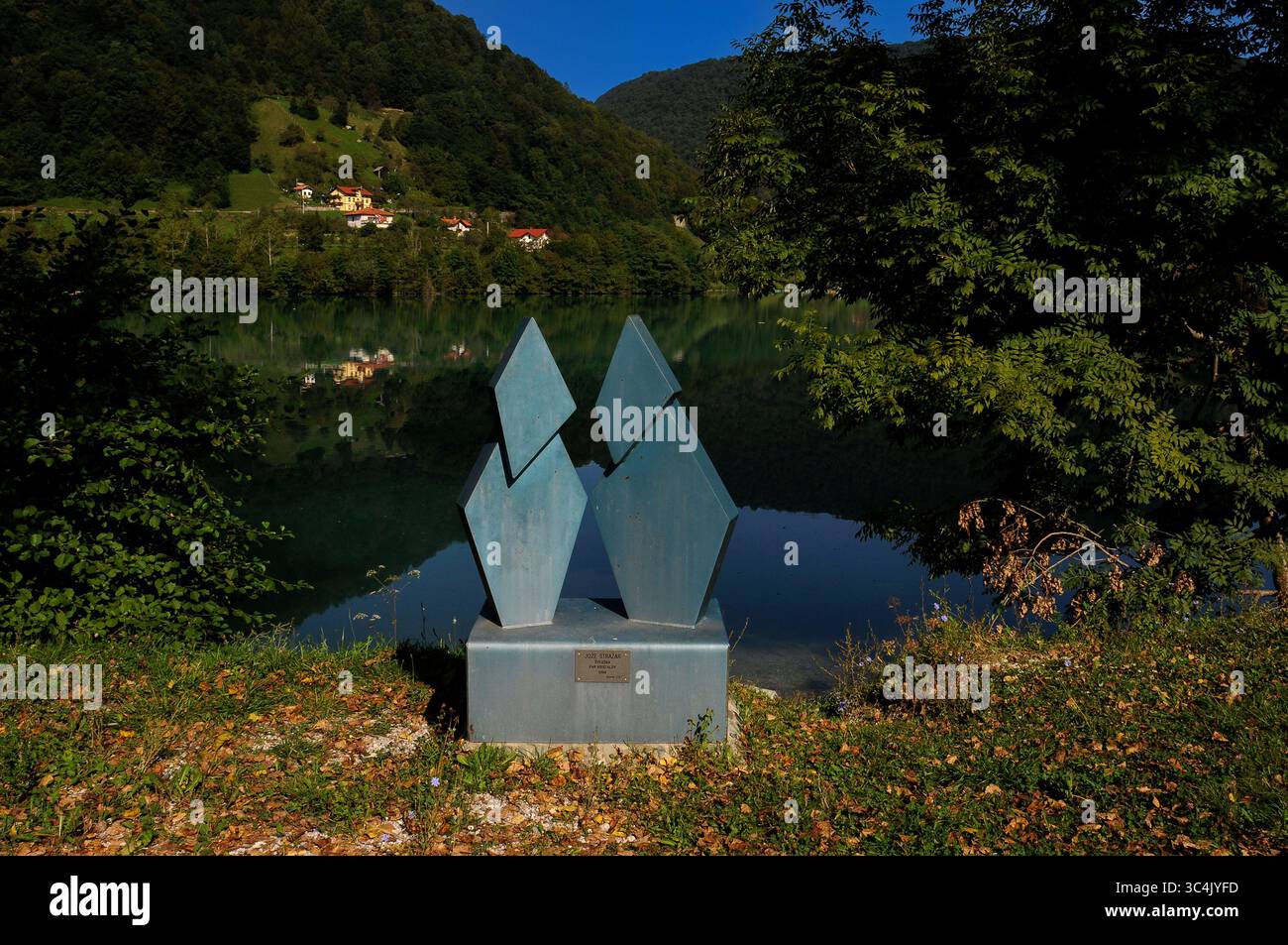 Una coppia di cristalli o Par Kristalov, scultura in bronzo sul lago dell'artista svedese Joze Strasar Kiyohara, esposta nel parco di sculture accanto alle calme acque verde smeraldo del bacino di Soci, al massimo na Soci nella regione litorale, Slovenia. Il lago si formò alla confluenza dei fiumi Soca e Idrijca dopo che il Soca fu disertato. Il fiume, chiamato "la bellezza di Smeraldo", sorge nelle Alpi Giulie. Foto Stock