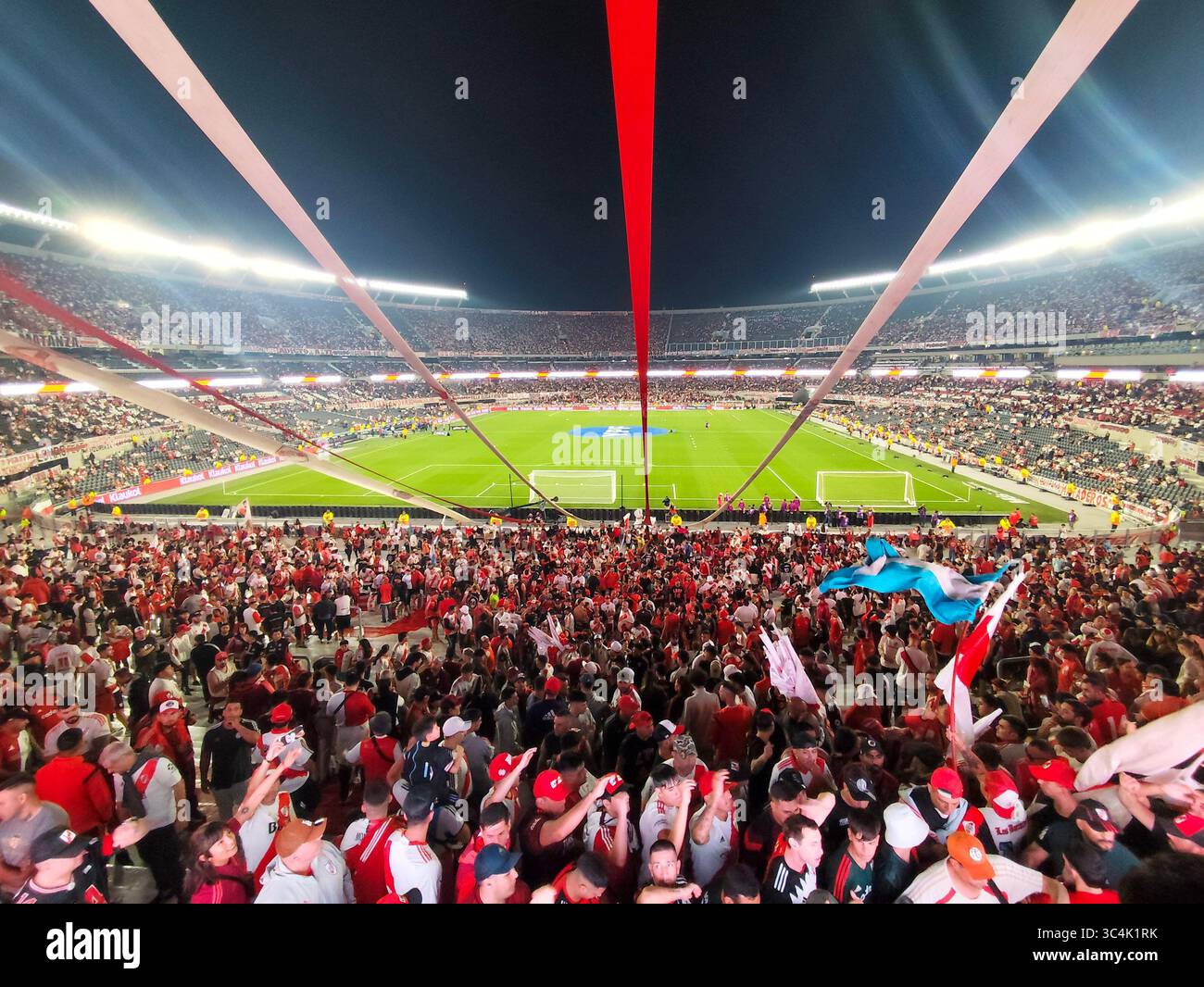 I tifosi del River Plate sventolano bandiere e gonfiabili durante una partita di calcio notturna all'Estadio Monumental di Buenos Aires, Argentina. Foto Stock