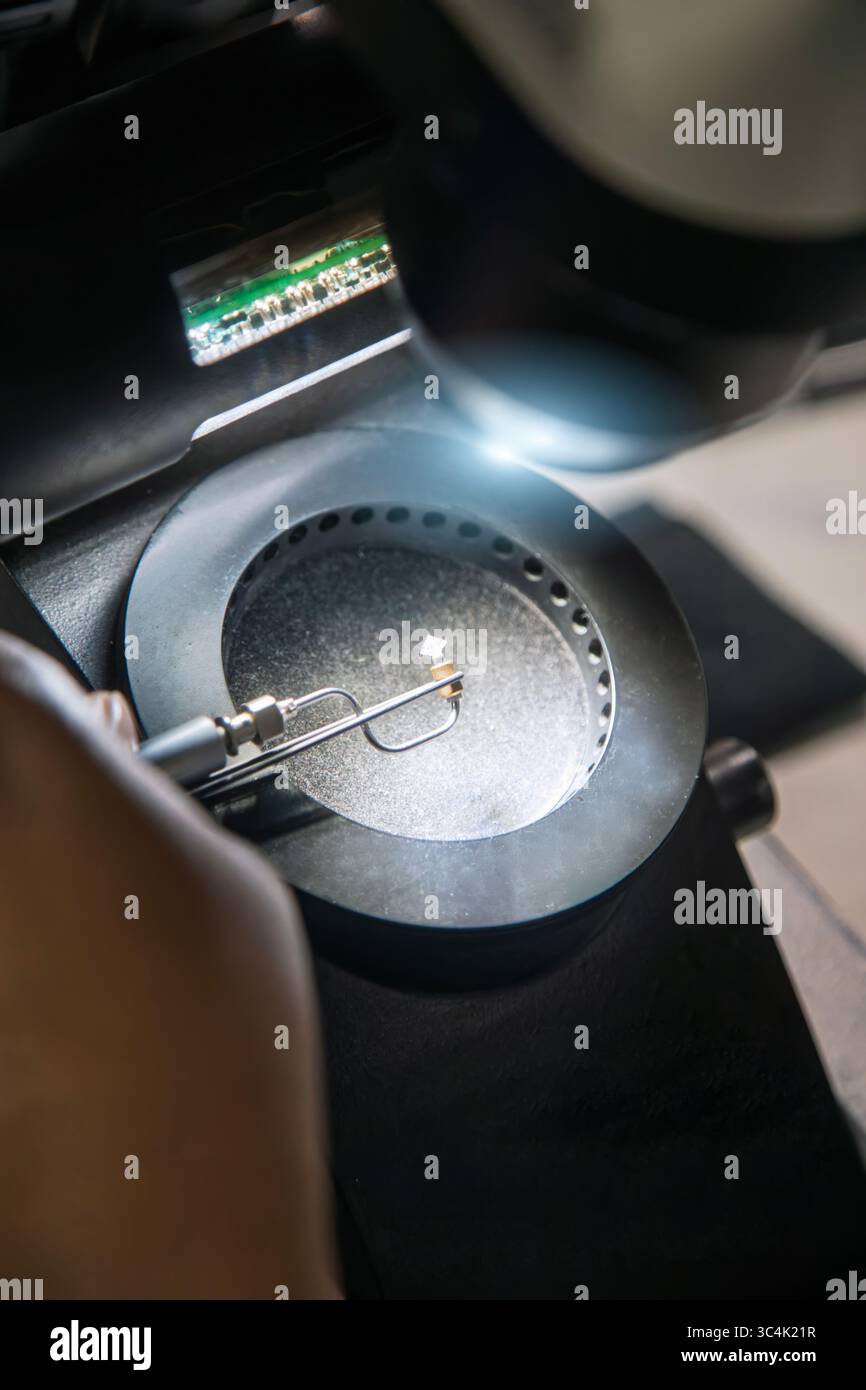 Classificazione dei diamanti per valutare la chiarezza, il taglio e la qualità in uno stabilimento in Botswana. Microscopio da laboratorio specializzato con luci a LED e un sistema di controllo di precisione Foto Stock