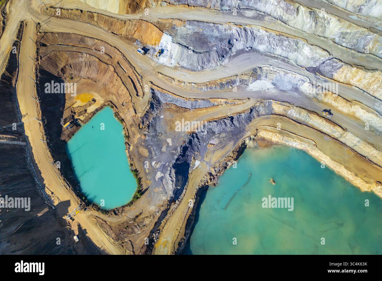 Vista aerea delle terrazze a strati della miniera di Erzberg in contrasto con le acque turchesi, a testimonianza dell'ambizione industriale, Eisenerz, Stiria, Austria. Foto Stock