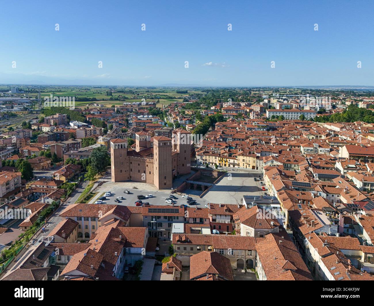 Veduta aerea dell'imponente Castello degli Acaja sorge orgogliosamente tra i tetti in terracotta e il paesaggio verdeggiante, Fossano, Piemonte, Italia. Foto Stock