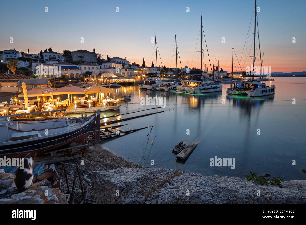 Palio Limani vecchio porto nella città di Spetses al tramonto con yacht e ristoranti, Spetses, isole Saroniche, isole greche, Grecia, Europa Foto Stock