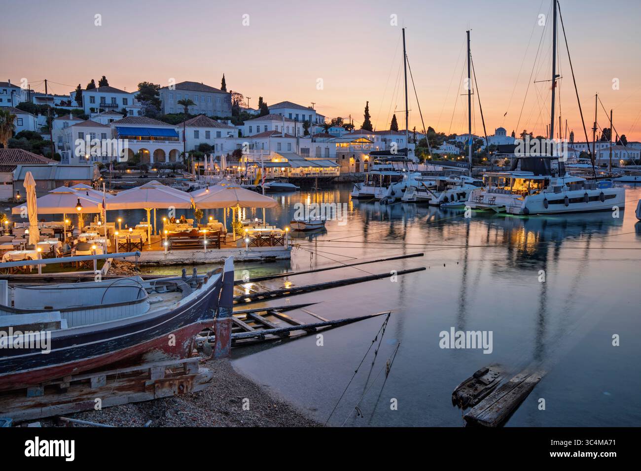 Palio Limani vecchio porto nella città di Spetses al tramonto con yacht e ristoranti, Spetses, isole Saroniche, isole greche, Grecia, Europa Foto Stock