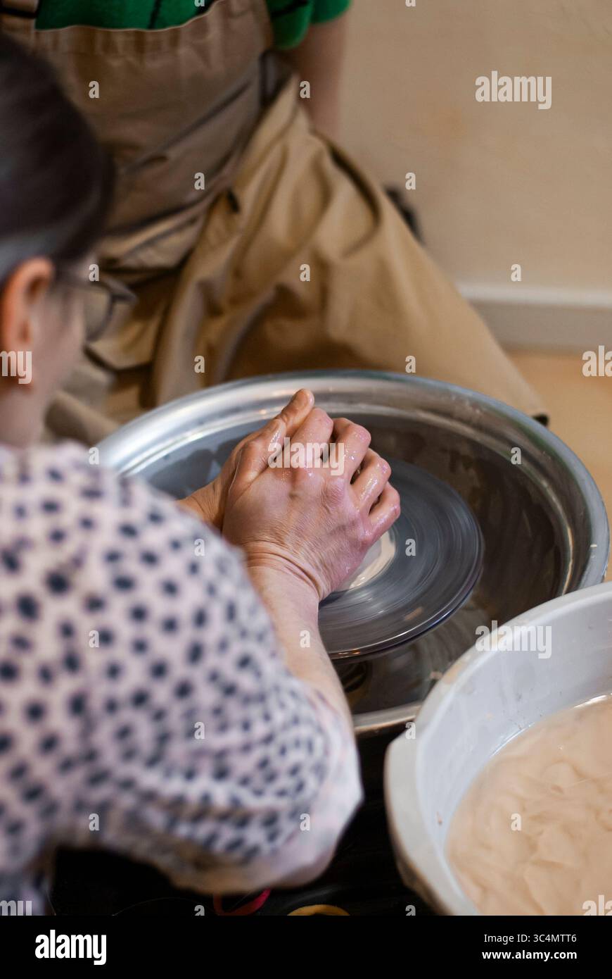Dita che scolpiscono i dettagli in argilla bagnata Foto Stock