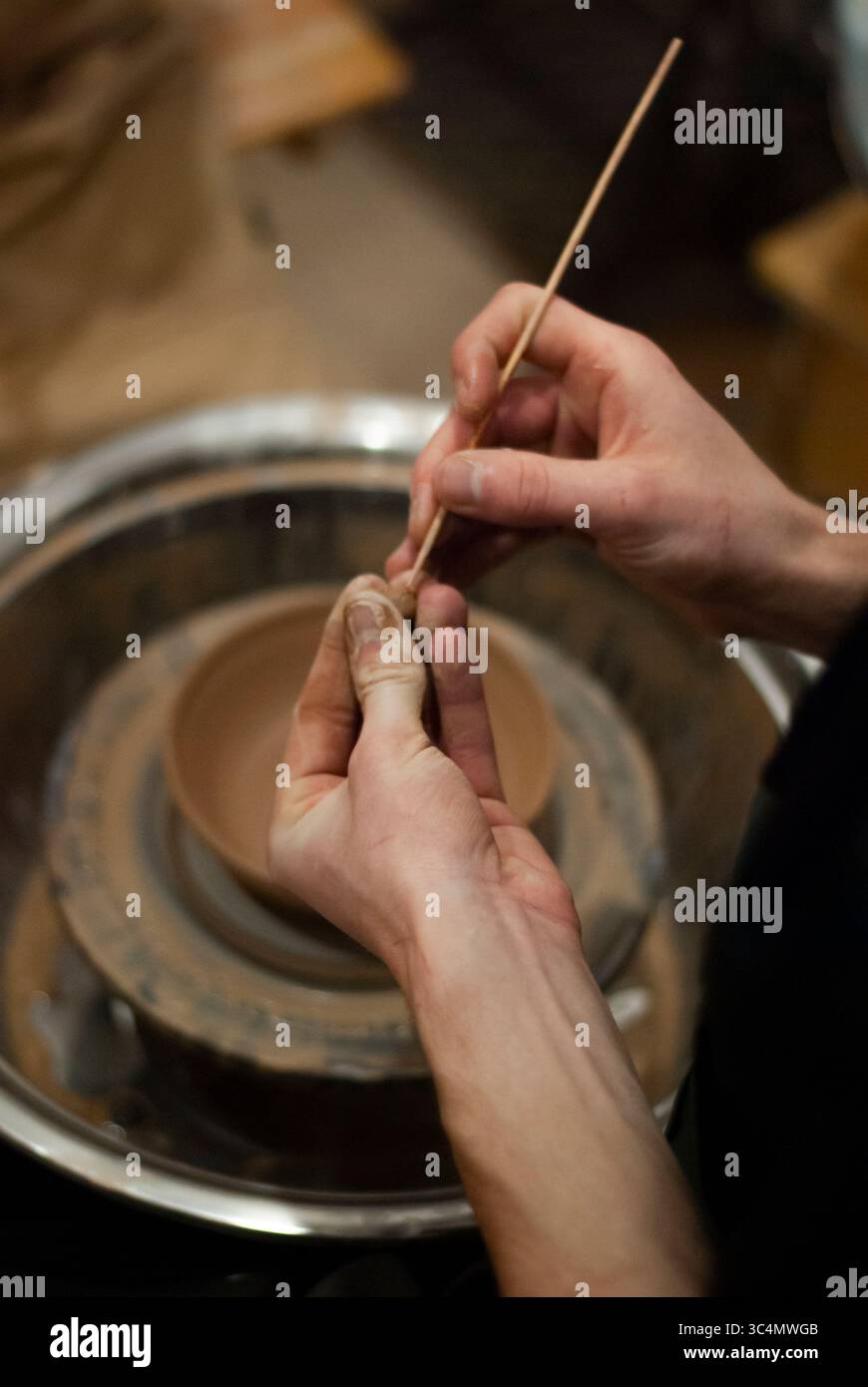 Artigiana che applica la vernice al piatto in ceramica Foto Stock