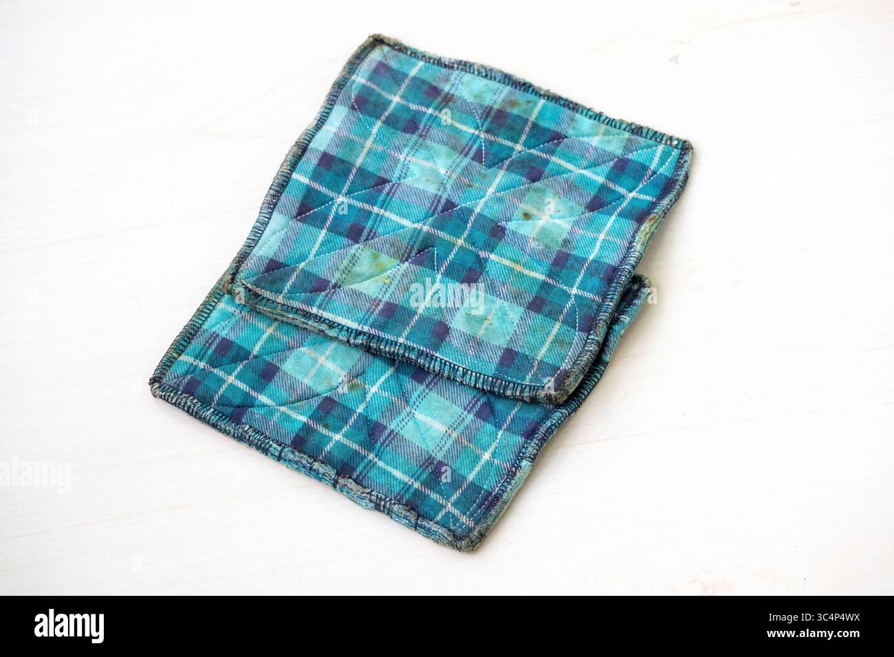 Porta pentole da cucina usati isolati su sfondo bianco con macchie di olio visibili. Tessuto resistente resistente resistente al calore per proteggere le mani da utensili da cucina caldi Foto Stock