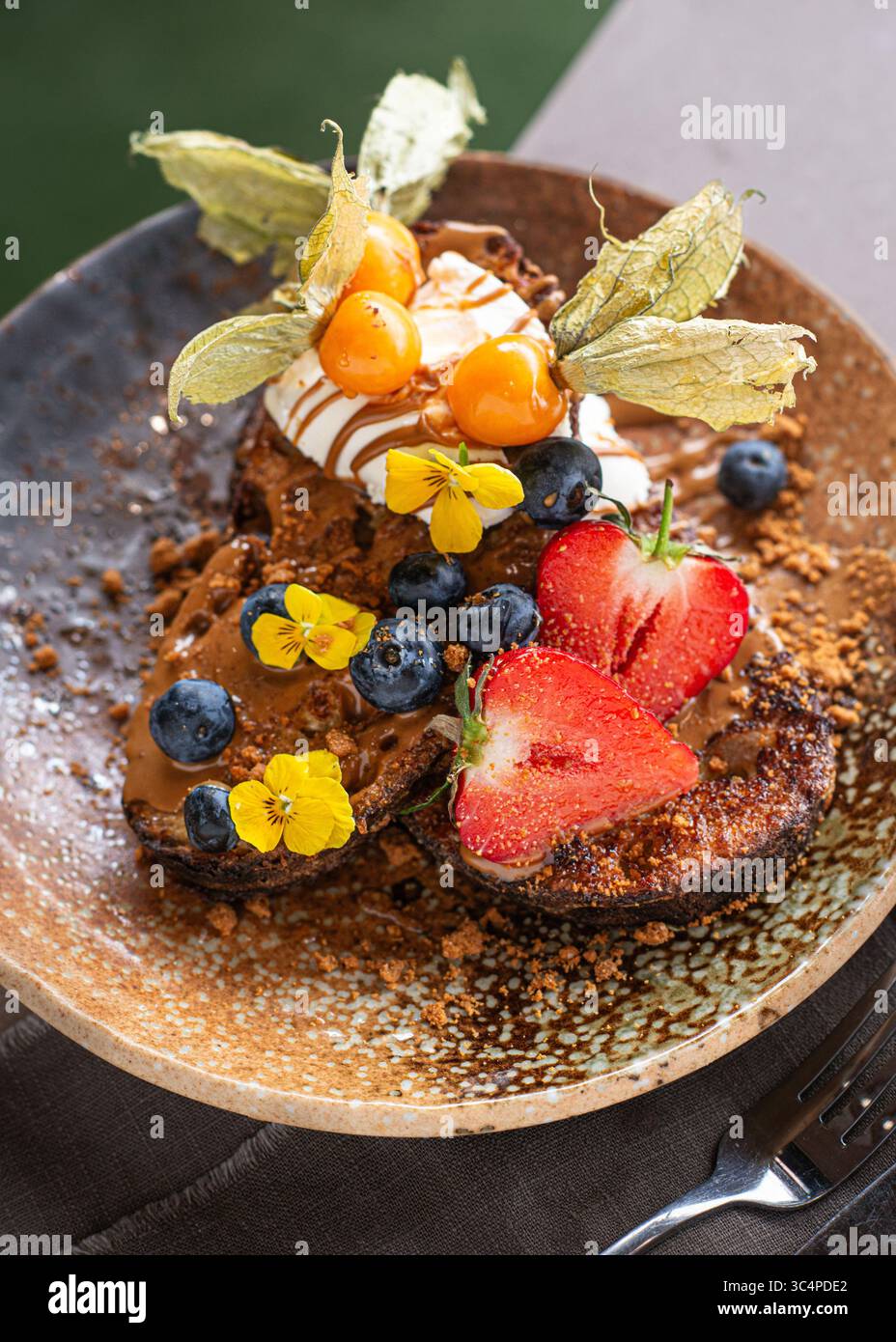 Un piatto di toast alla francese condito con frutti di bosco freschi e panna montata, servito come un delizioso e visivamente accattivante brunch. Colazione dolce fatta in casa Foto Stock