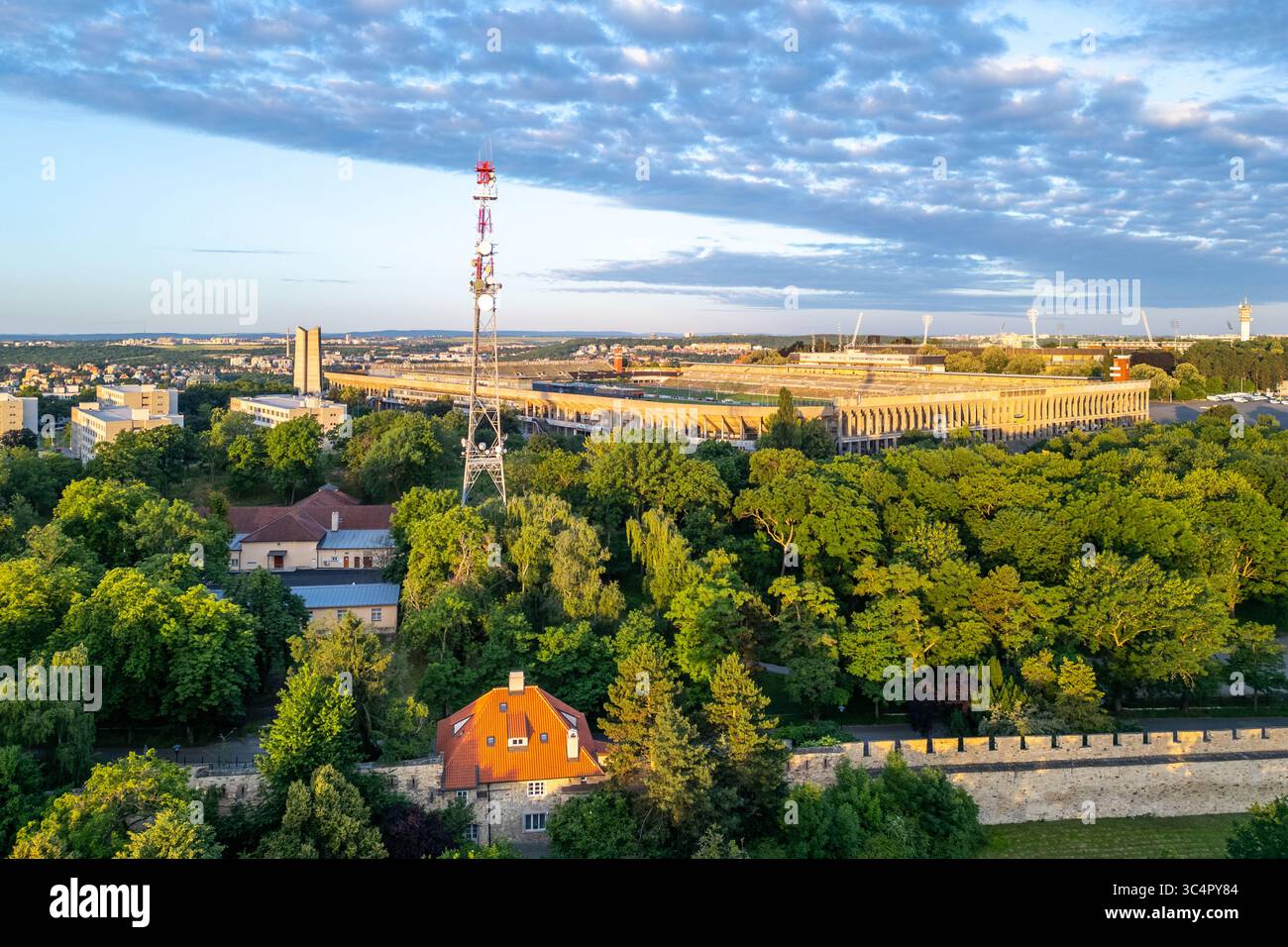 Il Great Strahov Stadium sorge in una posizione prominente a Praga, circondato da alberi lussureggianti e da un ambiente tranquillo. La scena cattura la bellezza di questo sito storico durante una giornata limpida. Foto Stock