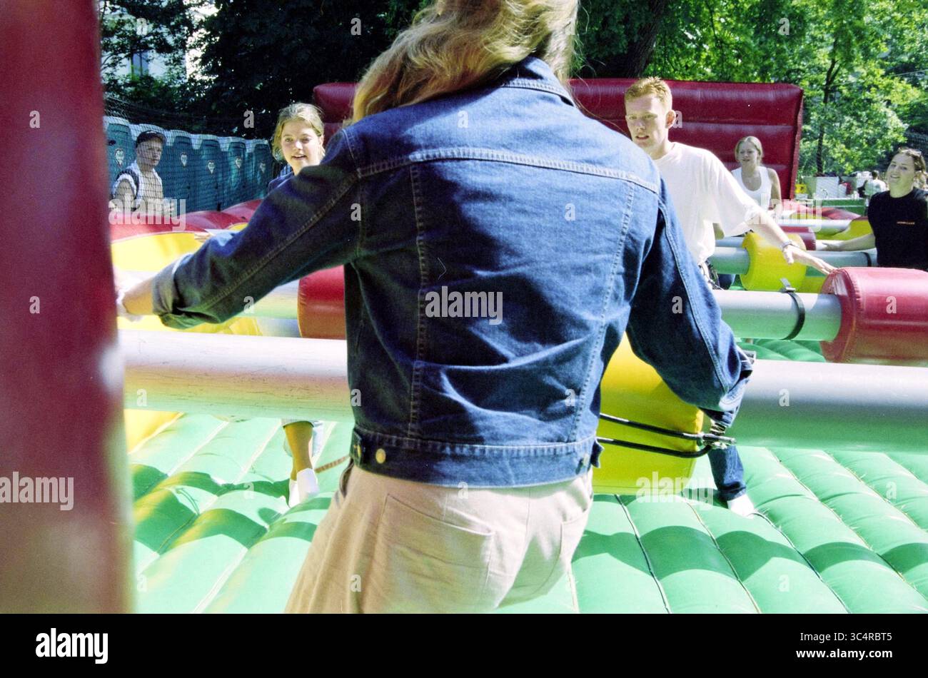 Giorno di introduzione HTS, Haarlem, Paesi Bassi, 28-08-2002 Whizgle News, Dutch Desk, i Paesi Bassi, 1950-2000 Una vivace scena all'aperto con persone impegnate in un divertente gioco gonfiabile. I partecipanti sono posizionati in vari punti, ciascuno dei quali interagisce con attrezzature colorate e di grandi dimensioni, mentre espressioni di entusiasmo e determinazione riempiono l'aria. L'ambiente e' vibrante e dinamico, suggerendo un'atmosfera gioiosa. Foto Stock