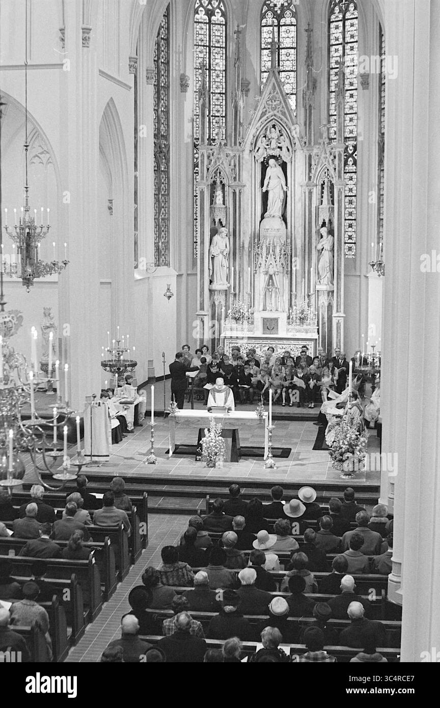 Inaugurazione della chiesa, Korte Zijlweg, chiese cattoliche romane, chiese R.C., Overveen, Korte Zijlweg, 04-04-1970 Whizgle News, Dutch Desk, Paesi Bassi, 1950-2000 Un gruppo di persone si riunisce in una grande chiesa ornata, ascoltando attentamente un oratore all'altare, adornato da intricate sculture e vetrate colorate. Le candele illuminano lo spazio, esaltando l'atmosfera solenne della cerimonia. Foto Stock