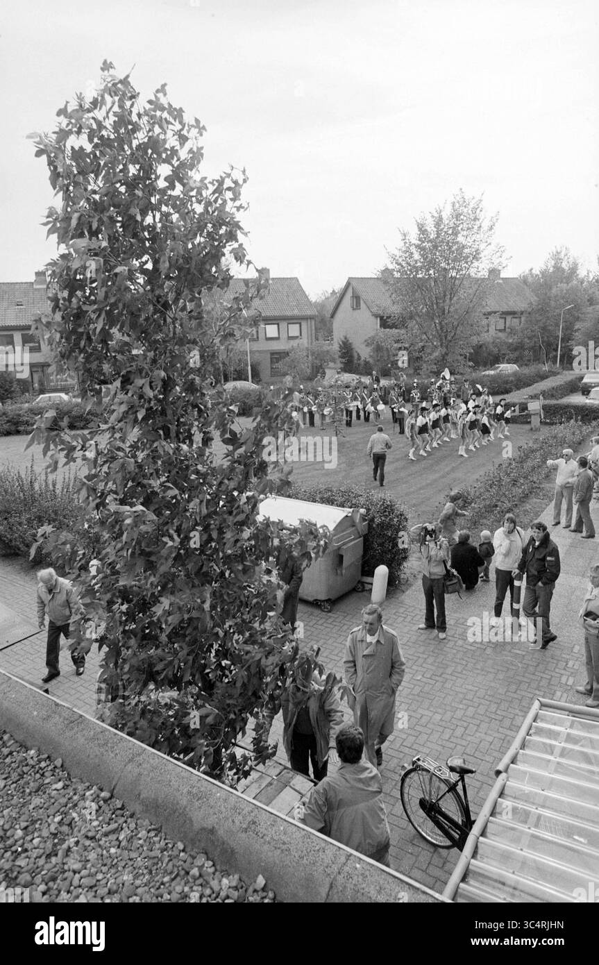 Albero per bej. Casa di Westerheim, New. Vennep, Trees, Nieuw-Vennep, 11-10-1987 Whizgle News, Dutch Desk, Paesi Bassi, 1950-2000 Un vivace raduno si svolge in una zona residenziale, con partecipanti impegnati in varie attività. In background, un gruppo esegue una routine, mentre gli individui socializzano nelle vicinanze. Una bicicletta si appoggia contro un muro e il verde aggiunge un tocco di natura alla scena. Foto Stock