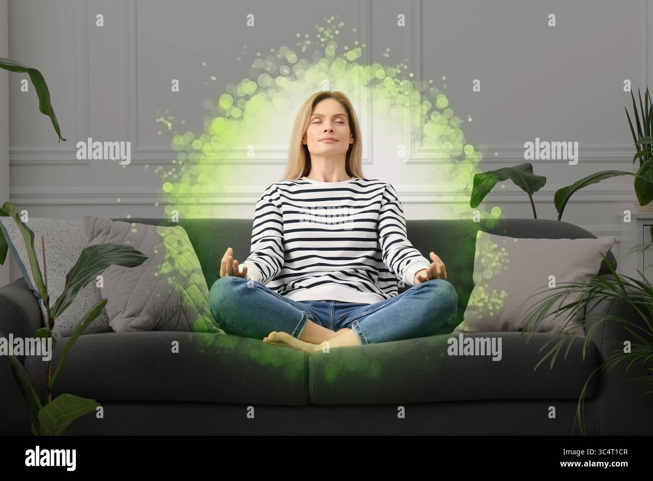Donna che meditava in posa Lotus a casa. Bolla intorno a lei che rappresenta l'aura Foto Stock
