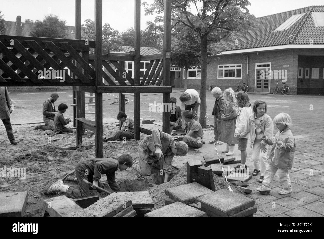 Costruzione di una cornice di gioco, scuola Juliana, giochi e giocattoli, 22-09-1987 Whizgle News, Dutch Desk, i Paesi Bassi, 1950-2000 Un vivace parco giochi cattura i bambini impegnati in varie attività: alcuni stanno scavando nella sabbia, mentre altri giocano nelle vicinanze. I dintorni presentano una struttura in legno e alberi, e alcune biciclette sono parcheggiate sullo sfondo, aggiungendo il senso di una vivace atmosfera da cortile scolastico. Foto Stock