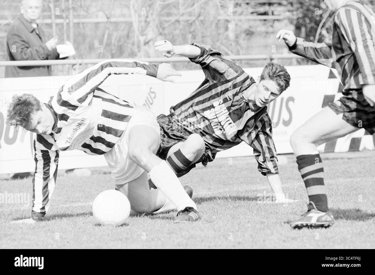 Football, EDO - Tonegido, 26-03-1994 Whizgle News, Dutch Desk, Paesi Bassi, 1950-2000 Un momento di tensione sul campo di calcio, in cui due giocatori si scontrano mentre lottano per la palla, mostrando l'intensità del gioco. Sullo sfondo, uno spettatore guarda con attenzione. Foto Stock