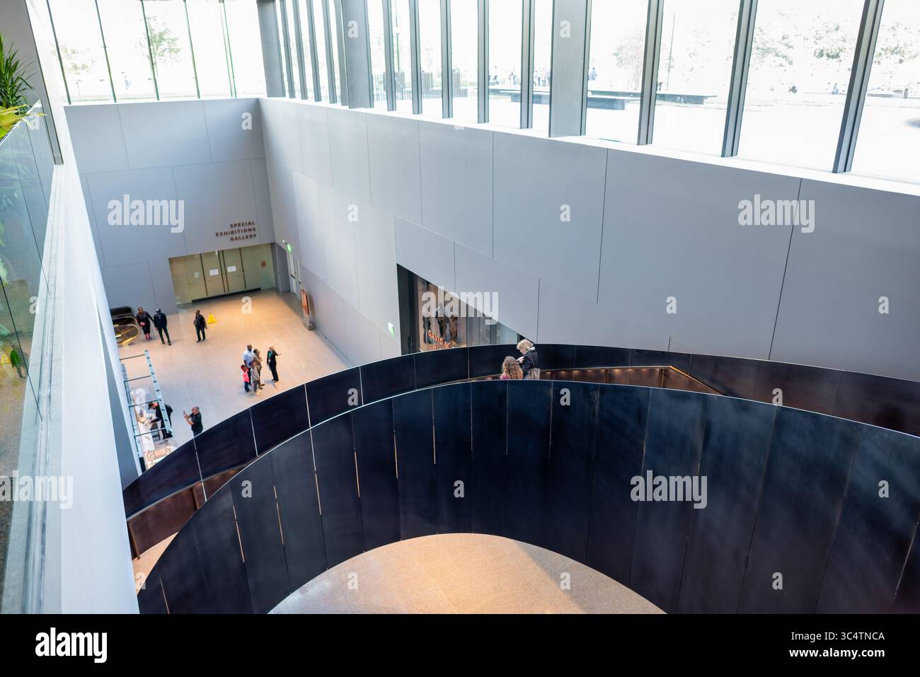 National Museum of African American History Stairway Washington DC // WASHINGTON DC - Una scala architettonica curva si snoda attraverso l'interno dello Smithsonian National Museum of African American History and Culture. Il museo, aperto nel 2016, è l'unico museo nazionale dedicato esclusivamente alla documentazione della vita, della storia e della cultura afroamericana. Progettato dall'architetto David Adjaye in collaborazione con il Freelon Group e Davis Brody Bond, l'edificio presenta una distintiva facciata a reticolo color bronzo ispirata all'arte yorubana e alle tradizioni del ferro americano. Il mus Foto Stock