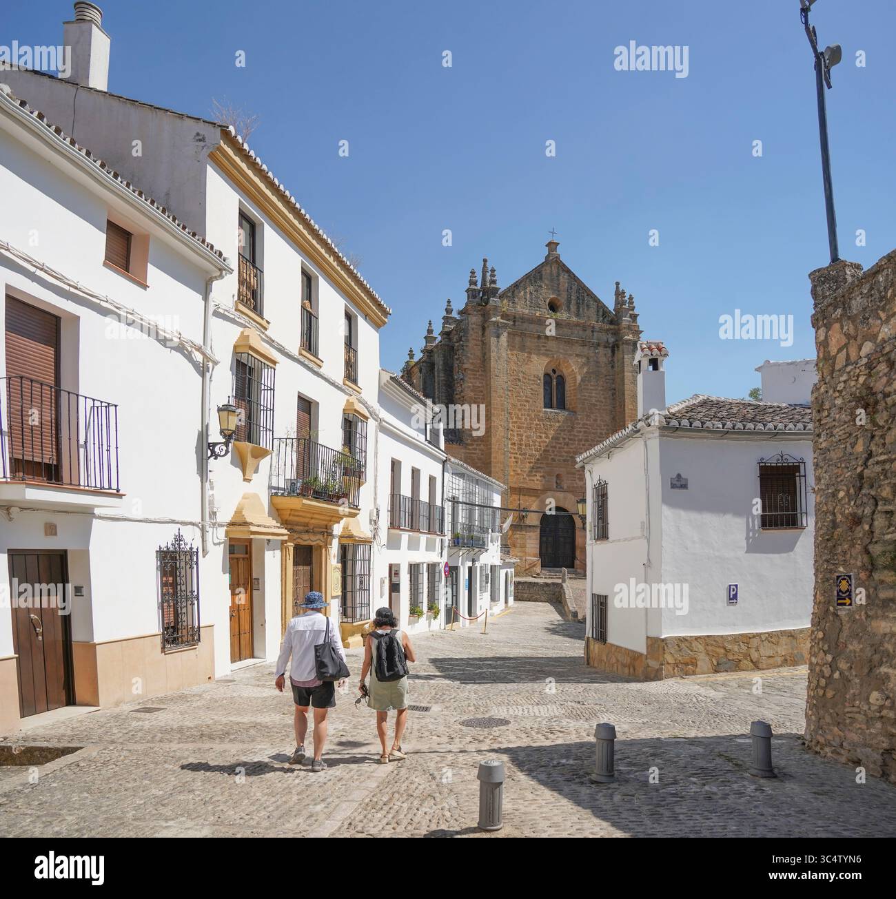 Vista sulla strada con ciottoli e case bianche spagnole nella città vecchia, nel centro storico di Ronda, Andalusia, Spagna. Foto Stock