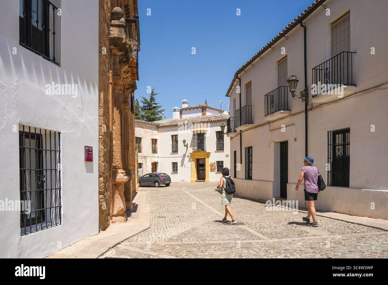 Vista sulla strada con ciottoli e case bianche spagnole nella città vecchia, nel centro storico di Ronda, Andalusia, Spagna. Foto Stock