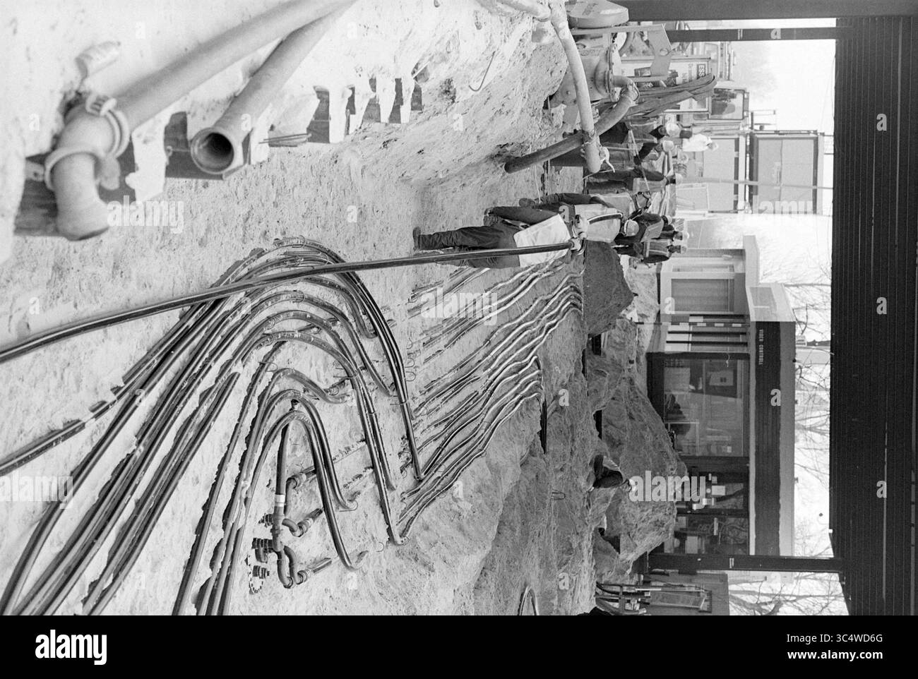 Renovation esso PUMP, Schipholweg, Schipholweg, 23-03-1995 Whizgle News, Dutch Desk, nei Paesi Bassi, 1950-2000 lavoratori stanno costruendo una rete di tubi e tubi flessibili in un cantiere, circondato da cumuli di terra e macchinari. La scena cattura la complessità delle utenze sotterranee che vengono installate in preparazione di un progetto più ampio. Foto Stock