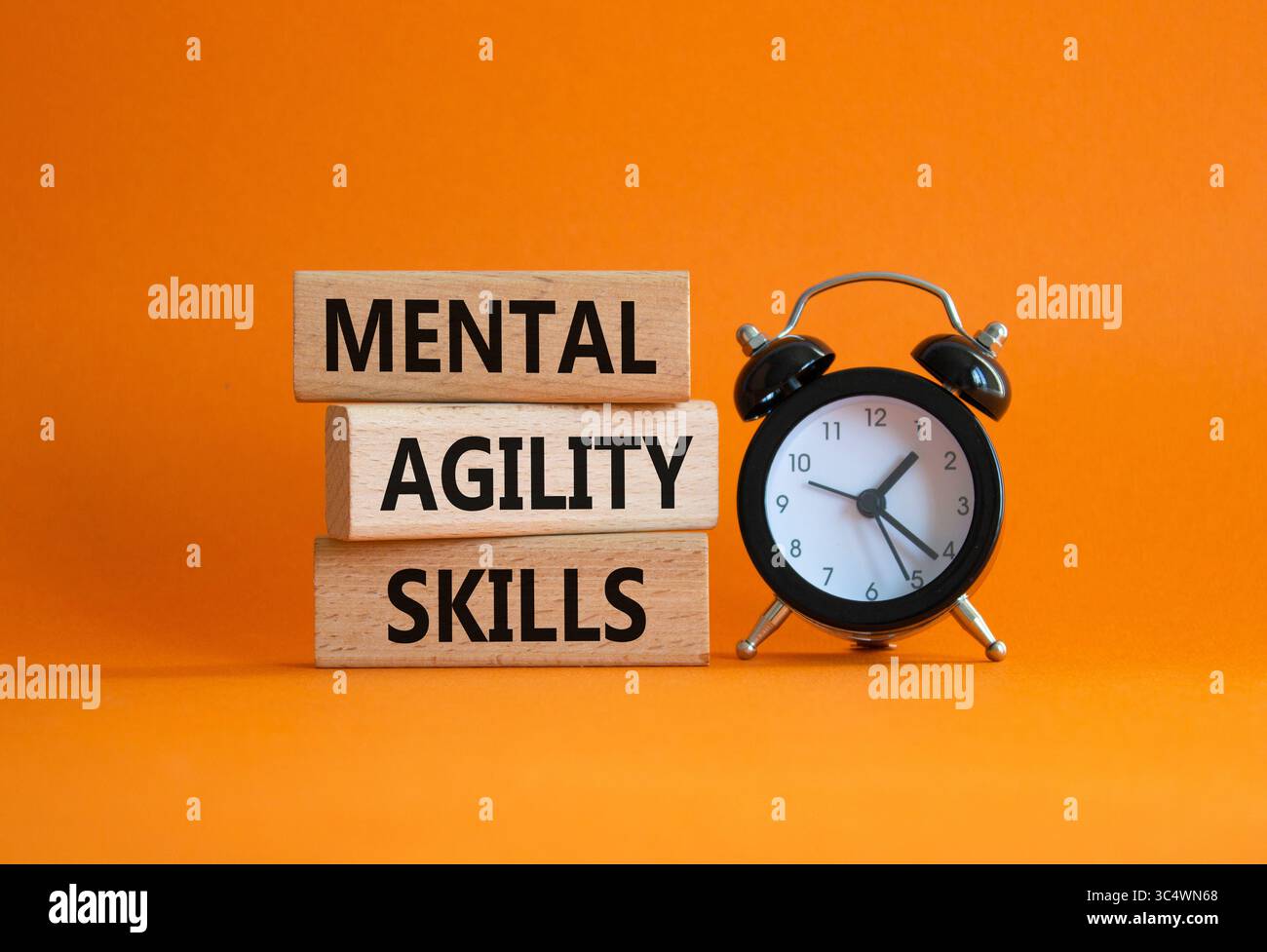 Simbolo delle abilità di agilità mentale. Parole concettuali capacità di agilità mentale su blocchi di legno. Splendido sfondo arancione con sveglia. Affari e mentali Foto Stock
