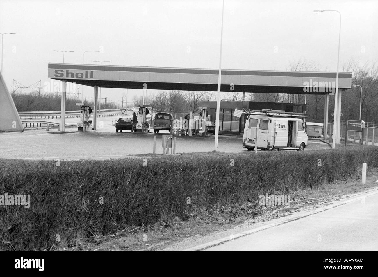 Tubi flessibili tagliati alla pompa a guscio Amsterdamsevaart, demolitions, Haarlem, Amsterdamsevaart, Paesi Bassi, 06-03-1988 Whizgle News, Dutch Desk, Paesi Bassi, 1950-2000 Una stazione di servizio Shell dispone di diverse pompe di carburante, con auto parcheggiate nelle vicinanze, circondate da basse siepi e una strada aperta: una tranquilla scena di vita automobilistica. Foto Stock