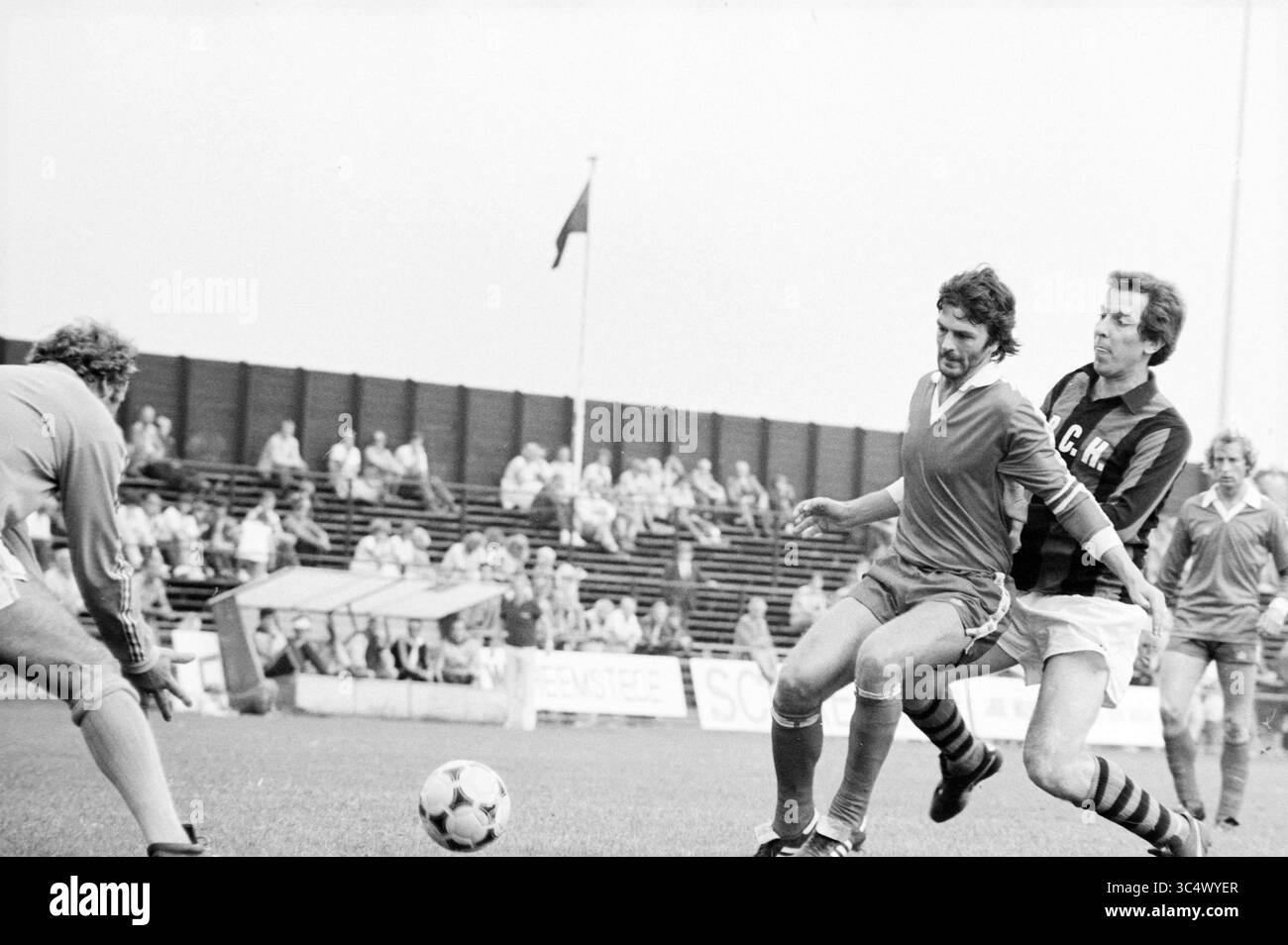 RCH - RDC, Football R.C.H., 21-09-1980 Whizgle News, Dutch Desk, Paesi Bassi, 1950-2000 Un momento di tensione sul campo di calcio in cui due giocatori lottano per il controllo del pallone, con gli spettatori che guardano con attenzione sullo sfondo. Un giocatore, con una maglia rossa, tenta di superare il suo avversario, mentre un compagno di squadra si prepara a sostenere il gioco. Foto Stock