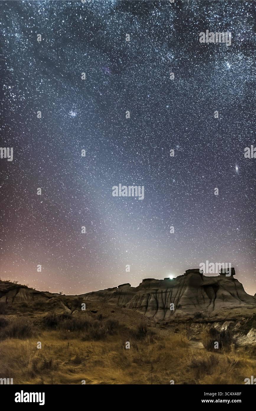 28 febbraio 2017 - Canada - The Late Winter Evening Zodiacal Light, AS shot at Dinosaur Provincial Park, Alberta, 28 febbraio 2017. La luce è il bagliore della luce solare che riflette le particelle di polvere delle comete nel sistema solare interno. Non è un effetto del crepuscolo. È meglio visibile di sera dalle latitudini settentrionali nel tardo inverno e in primavera. ..Venere si trova appena sopra il paesaggio calanchi. La Galassia Andromeda è a destra, le Pleiadi a sinistra. La via Lattea attraversa il fotogramma nella parte superiore...si tratta di una pila di 7 esposizioni da 30 secondi per il terreno, media combinata per un rumore inferiore, p Foto Stock
