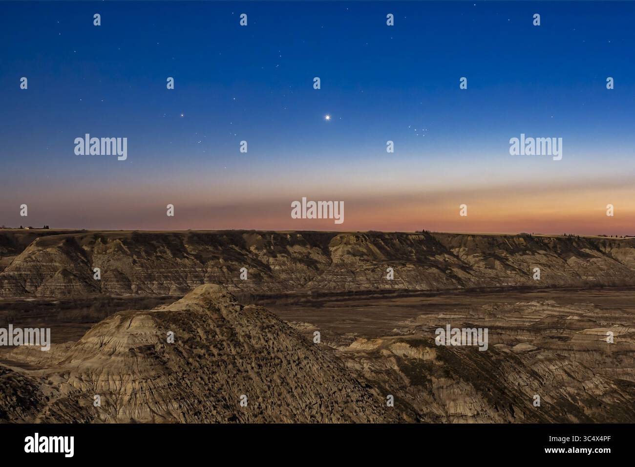 27 aprile 2018 - Alberta, Canada - Venere al crepuscolo serale tra gli ammassi stellari di Hyades (a sinistra) e Pleiadi (a destra) in Toro, il 27 aprile 2018. L'ho scattato dal punto di vista dell'Horsethief Canyon sul fiume Red Deer a nord di Drumheller, Alberta... si tratta di una pila di 6 esposizioni di 13 secondi a ISO 400 per il terreno per un rumore uniforme e di un'esposizione di 8 secondi a ISO 800 per il cielo per ridurre al minimo il trailing. Il tutto a f/4 con un obiettivo da 35 mm sulla Canon 60DA per una maggiore sensibilità del rosso nei colori del cielo. L'apertura f/4 più piccola ha aggiunto i picchi di diffrazione su Venere â€œnaturallyâ€ in camma Foto Stock