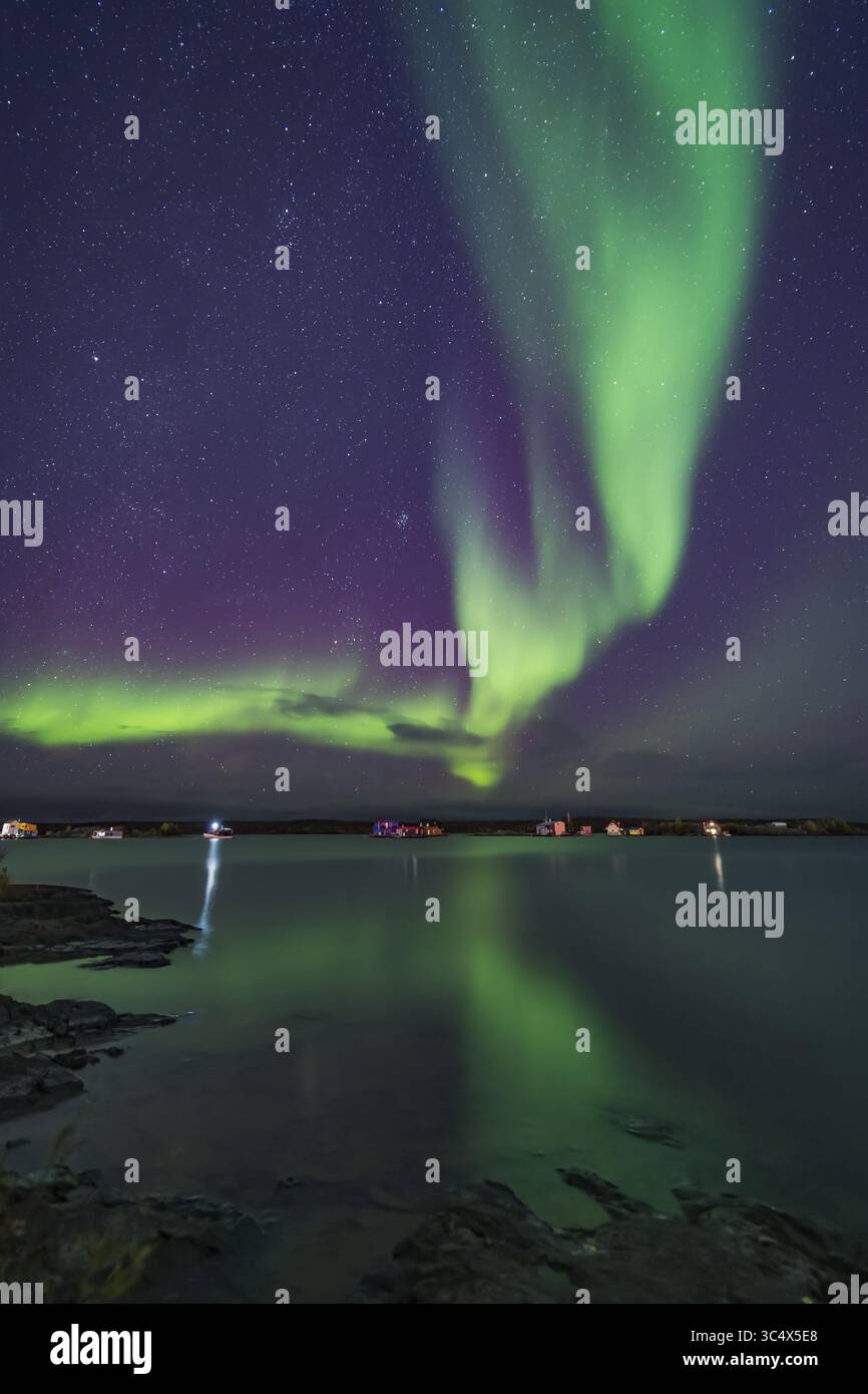 12 settembre 2018 - Alberta, Canada - Una tenda di aurora spazza sopra le case galleggianti ormeggiate sulla Yellowknife Bay a Yellowknife, NWT, l'11 settembre 2018. ..le Pleiadi e Hyades ammassi stellari del Toro stanno sorgendo a sinistra. Si tratta di una pila combinata media di 8 immagini per uniformare il rumore per il terreno e l'acqua, e di una singola esposizione per il cielo e le case galleggianti stesse (in quanto si muovevano leggermente dall'esposizione all'esposizione). Ciascuno era di 13 secondi a f/2 con l'obiettivo Venus Optics da 15 mm e Sony a7III a ISO 3200. (Immagine di credito: © Alan Dyer / Vwpics/VW Pics tramite cavo ZUMA) Foto Stock