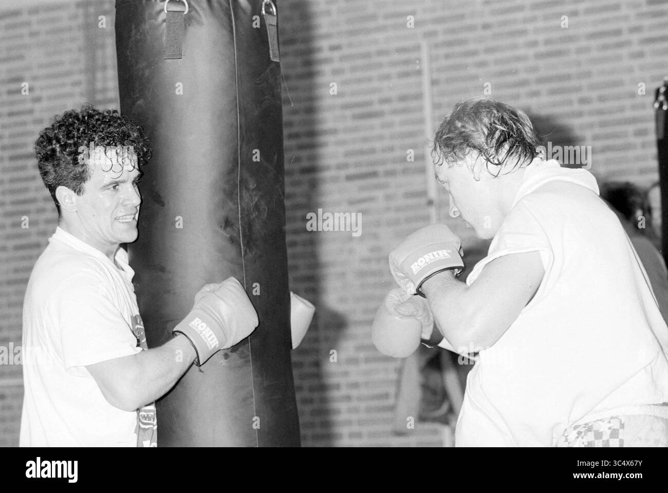 Scuola di pugilato Roja, Haarlem, Reviusstraat, Paesi Bassi, 27-02-1995 Whizgle News, Dutch Desk, Paesi Bassi, 1950-2000 due persone si allenano indossando guanti da boxe e si concentrano sulla loro tecnica. Uno colpisce una borsa pesante, mentre l'altro guarda con attenzione, dimostrando determinazione e dedizione alla loro pratica. Foto Stock