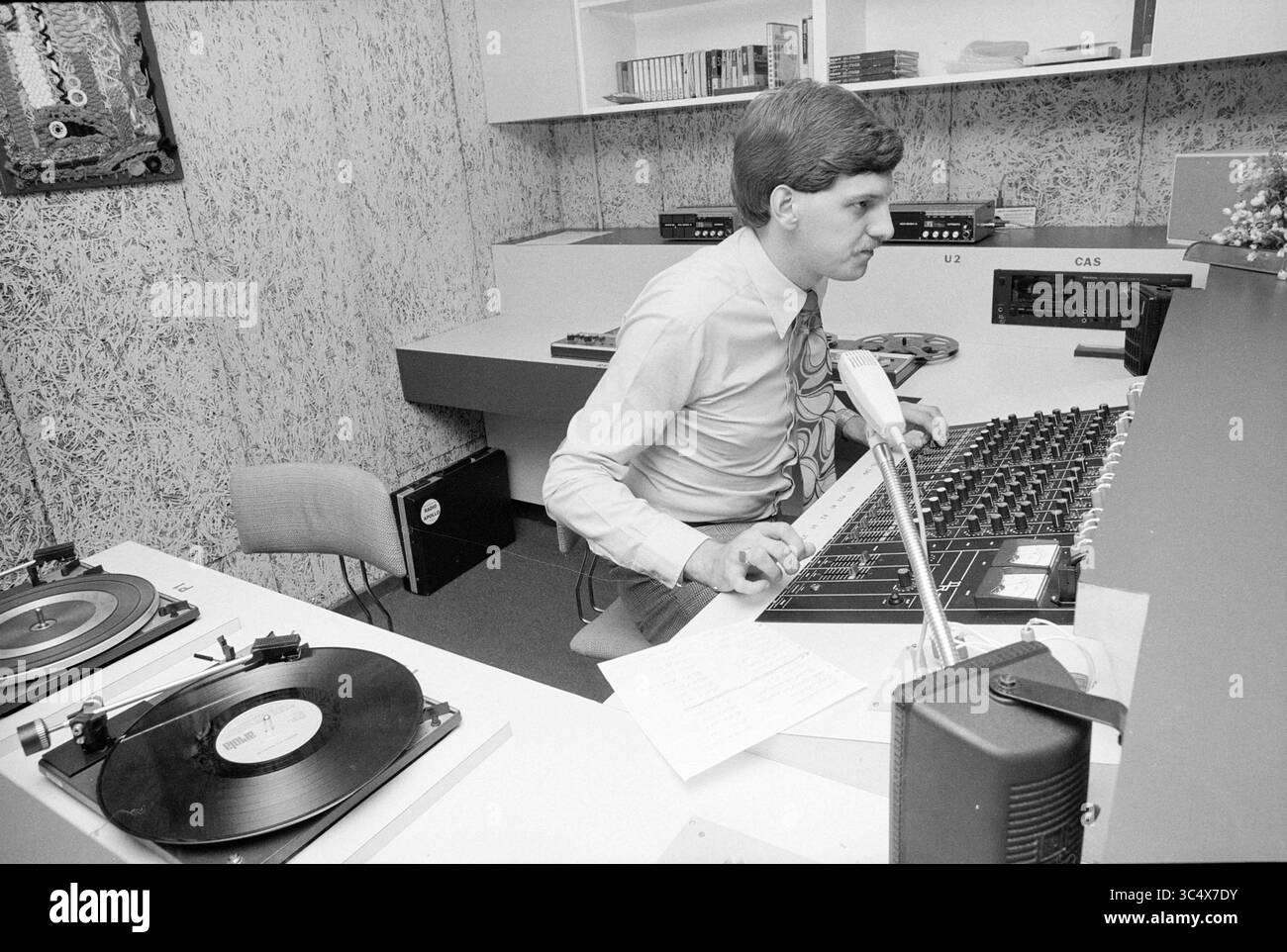 Nuovo studio di salute emittente Apollo, radio, ospedali, 11-07-1980 Whizgle News, Dutch Desk, i Paesi Bassi, 1950-2000 Un uomo concentrato gestisce un mixer audio seduto in uno studio, circondato da attrezzature musicali. Sono visibili un lettore di dischi in vinile e un mazzo di cassette, insieme a una pila di CD e note. Foto Stock