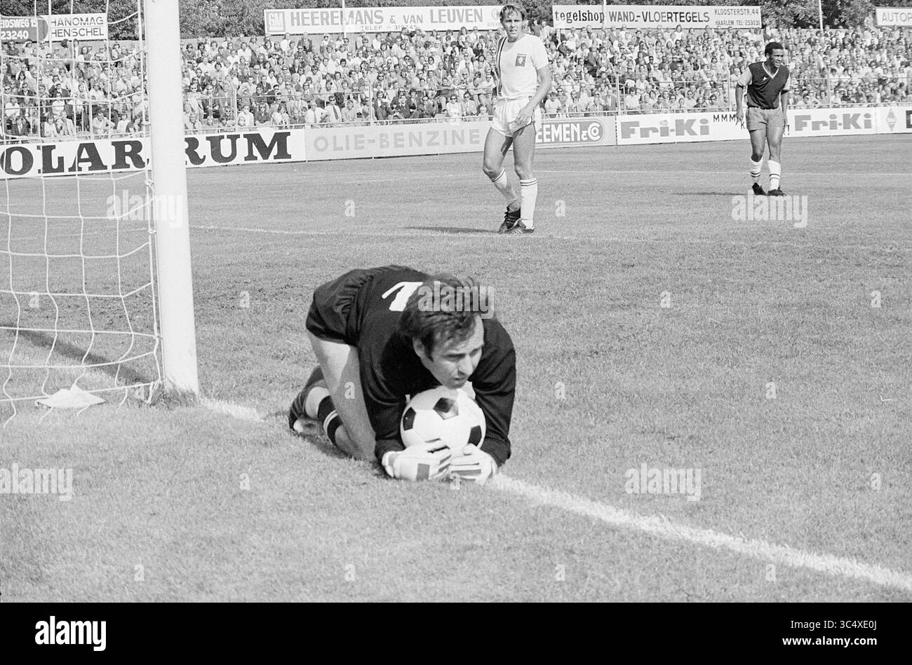 Haarlem - FC Twente, Football Haarlem, 29-08-1972 Whizgle News, Dutch Desk, Paesi Bassi, 1950-2000 Un portiere cattura abilmente un pallone da calcio vicino alla linea della porta, mostrando concentrazione tra una folla di spettatori sullo sfondo. I compagni di squadra vengono posizionati sul campo mentre il gioco si svolge. Foto Stock