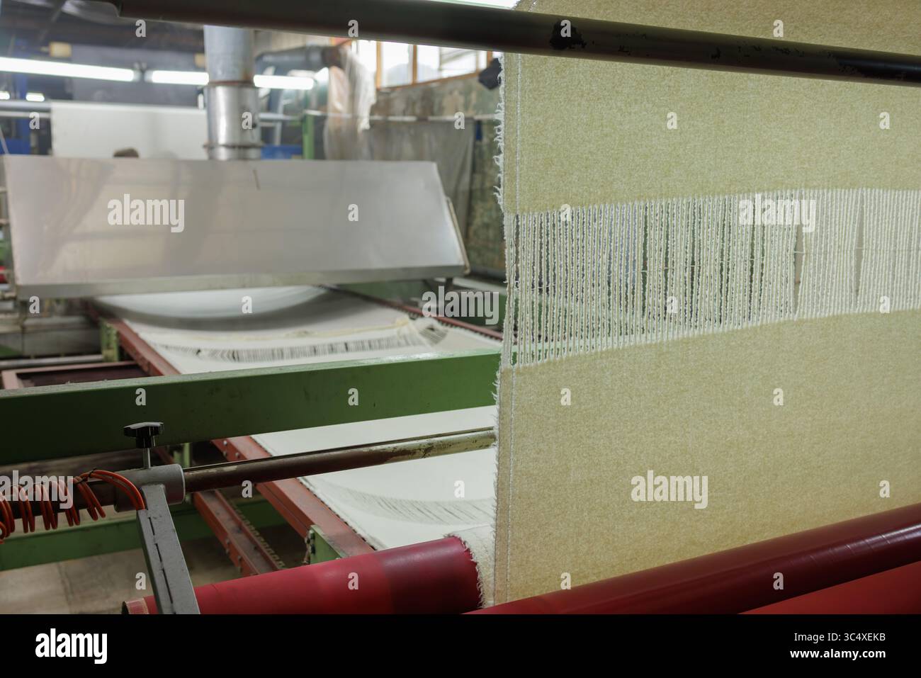 Linea di produzione di tessuti di lana con tessitura in fabbrica tessile, che mostra il processo industriale e i fili per la produzione di indumenti. Foto Stock