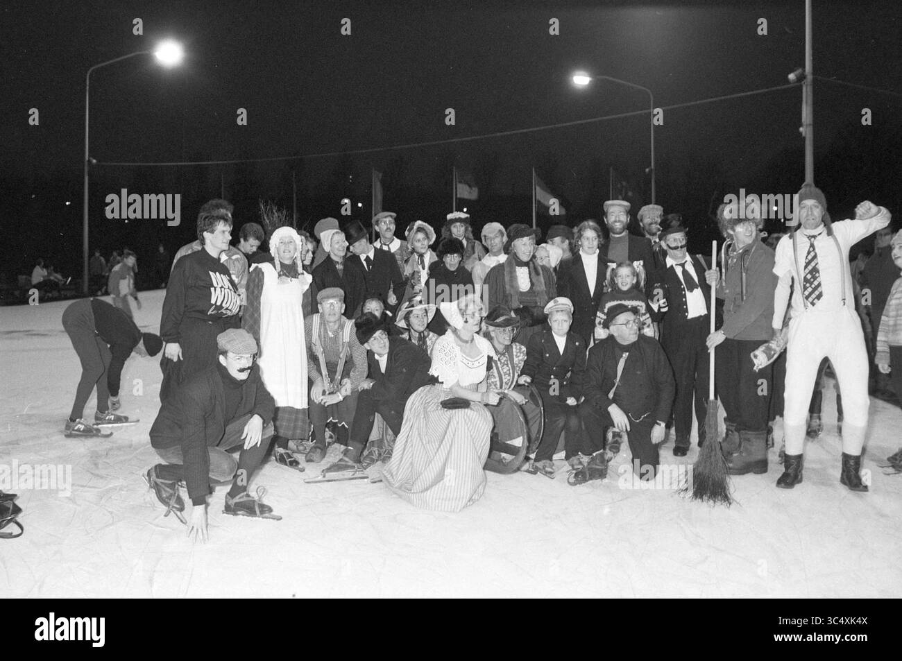 Serata di pattinaggio nostalgico in occasione del 120° anniversario del club di pattinaggio su ghiaccio Haarlem, Skating, Haarlem, Paesi Bassi, 14-01-1989 Whizgle News, Dutch Desk, Paesi Bassi, 1950-2000 Un vivace gruppo di persone si è riunito su una pista di pattinaggio, indossando vari abiti invernali, tra cui cappelli e sciarpe. Alcuni stanno potendo allegramente, mentre altri si impegnano in attività ludiche, creando un'atmosfera festosa sotto il bagliore delle luci vicine. Foto Stock