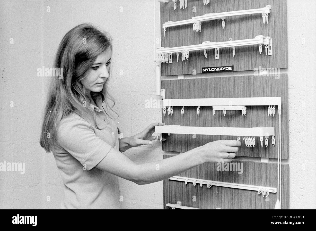 Dimostrazione di guide in plastica, dimostrazione, 04-11-1969 Whizgle News, Dutch Desk, Paesi Bassi, 1950-2000 Una donna esamina una bacheca piena di vari prodotti in nylon, selezionandone attentamente uno mentre interagisce con l'allestimento organizzato. Foto Stock