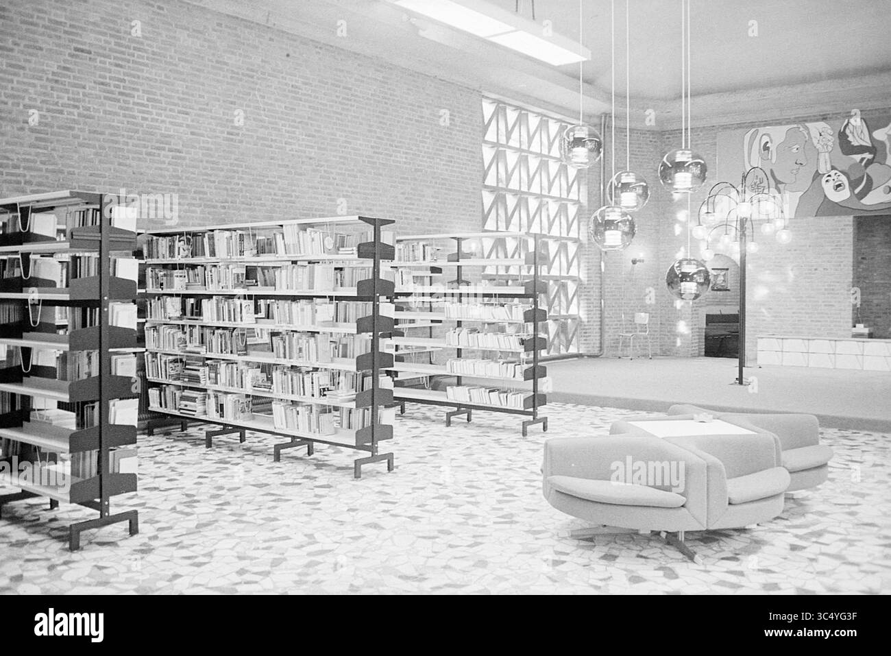 Interno di una biblioteca Whizgle News, Dutch Desk, Paesi Bassi, 1950-2000 Un moderno spazio biblioteca con eleganti scaffali pieni di libri, eleganti disposizione dei posti a sedere e illuminazione contemporanea, il tutto su uno sfondo di pareti in mattoni testurizzati e un vivace murale. Foto Stock Interno di una biblioteca Whizgle News, Dutch Desk, Paesi Bassi, 1950-2000 Un moderno spazio biblioteca con eleganti scaffali pieni di libri, eleganti disposizione dei posti a sedere e illuminazione contemporanea, il tutto su uno sfondo di pareti in mattoni testurizzati e un vivace murale. Foto Stock