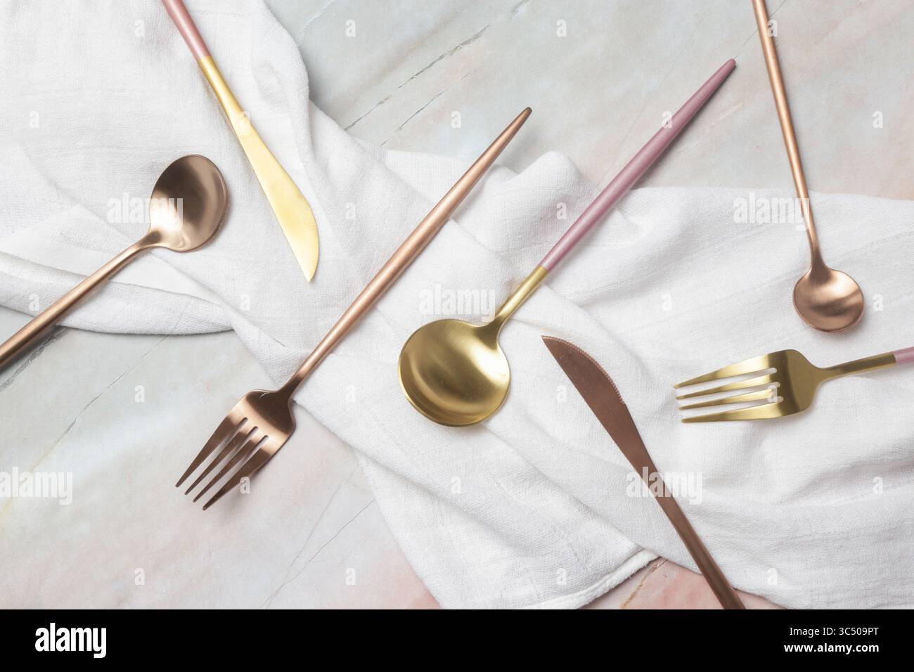 Immagine creativa di posate dorate su un tavolo in marmo, Design Concept. Cucina moderna. Stoviglie in stile scandinavo. Foto Stock