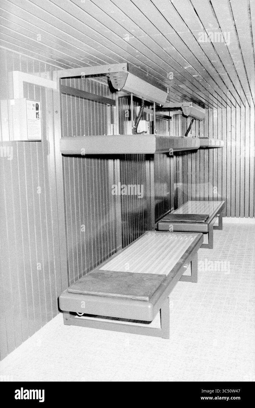 Area con due lettini, Whizgle News, Dutch Desk, The Netherlands, 1950-2000 Uno spazio interno minimalista con due lunghe panche attaccate alle pareti, con eleganti linee orizzontali e un soffitto strutturato sopra. Il design enfatizza la semplicità e la funzionalità, creando un ambiente organizzato e spazioso. Foto Stock