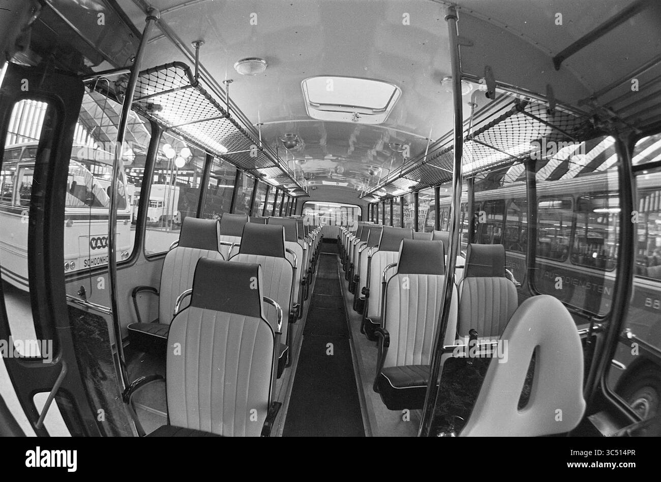 Stand RAI e visita di apertura del Ministro Aartsen, Verheul Carosseriefabriek Waddinxveen, 06-02-1964 Whizgle News, Dutch Desk, Paesi Bassi, 1950-2000 l'interno di un autobus d'epoca presenta file di posti a sedere ordinati, con spazi vuoti che evidenziano un senso di nostalgia. Sopra l'alto, un lucernario offre un'occhiata all'esterno, mentre pali metallici e rete metallica aggiungono un fascino retrò all'ambientazione. Foto Stock