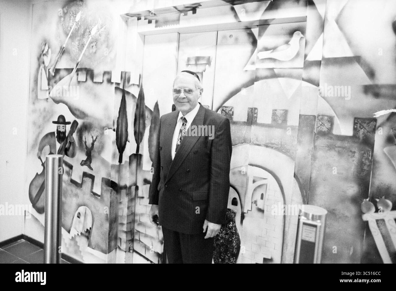 Schijveschuurder, Amsterdam, Amsterdam, Paesi Bassi, 24-06-1992 Whizgle News, Dutch Desk, Paesi Bassi, 1950-2000 Un uomo in tuta si trova di fronte a un vivace murale che raffigura forme e figure astratte, con elementi artistici che ricordano un castello e vari simboli sullo sfondo. Foto Stock